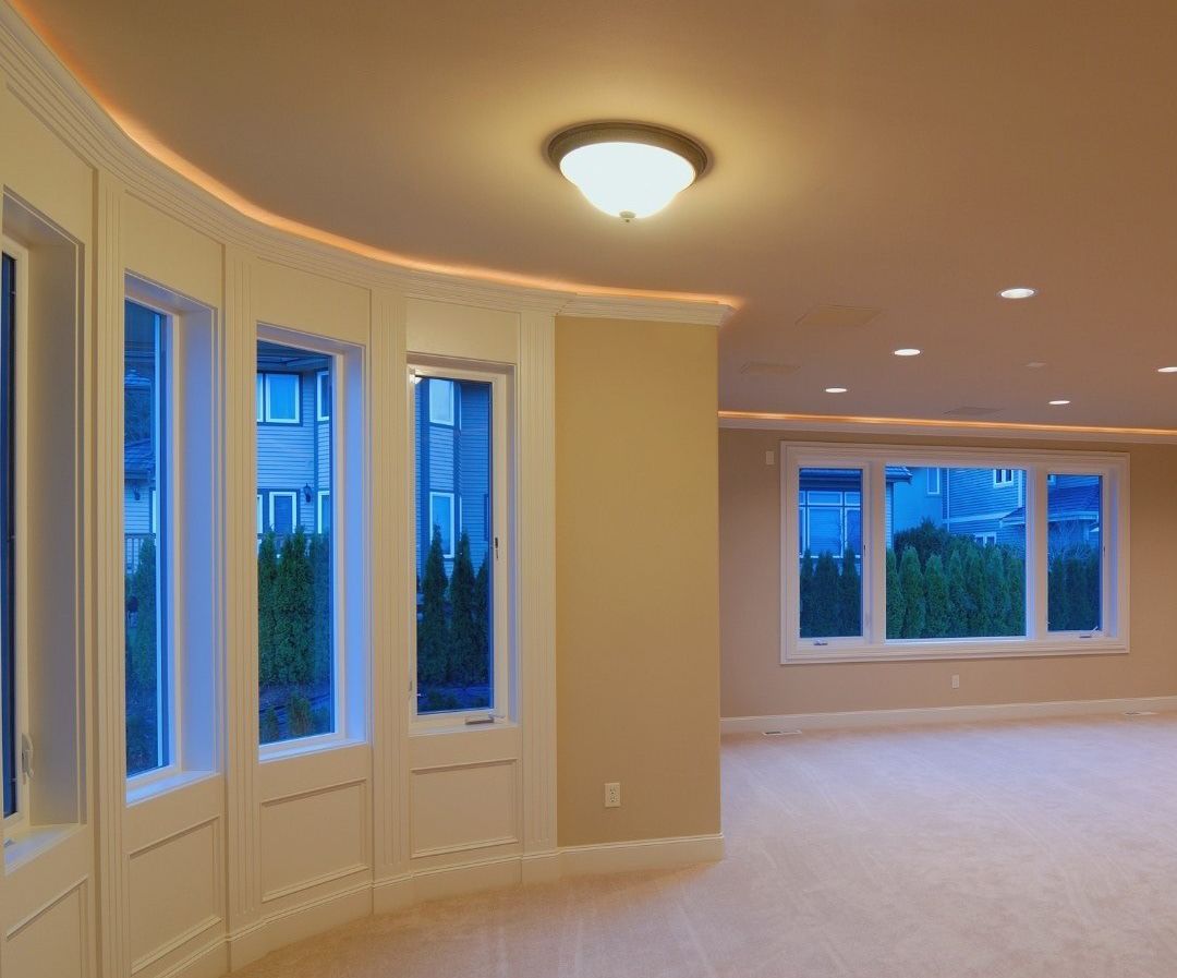 An empty room with a lot of windows and a ceiling light