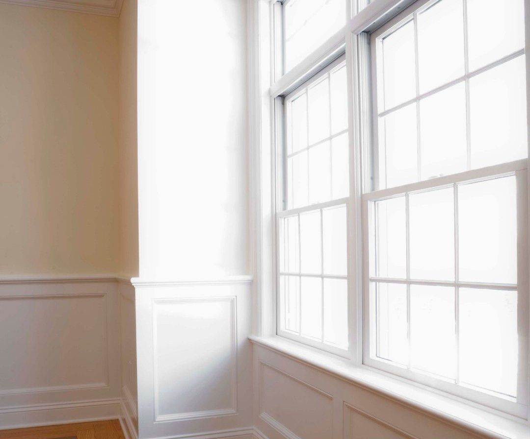 A room with a lot of windows and a wooden floor.