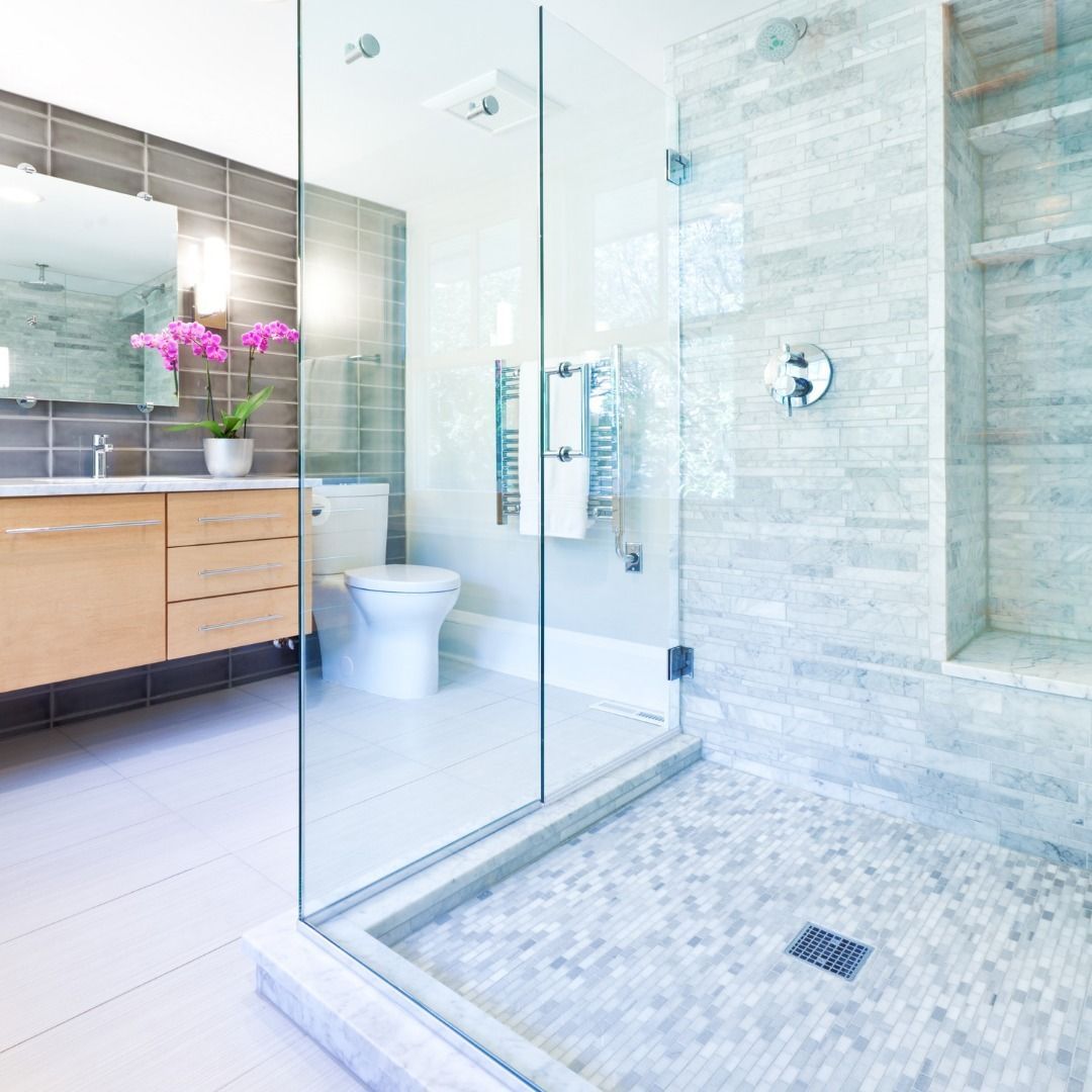 A bathroom with a toilet a sink and a walk in shower