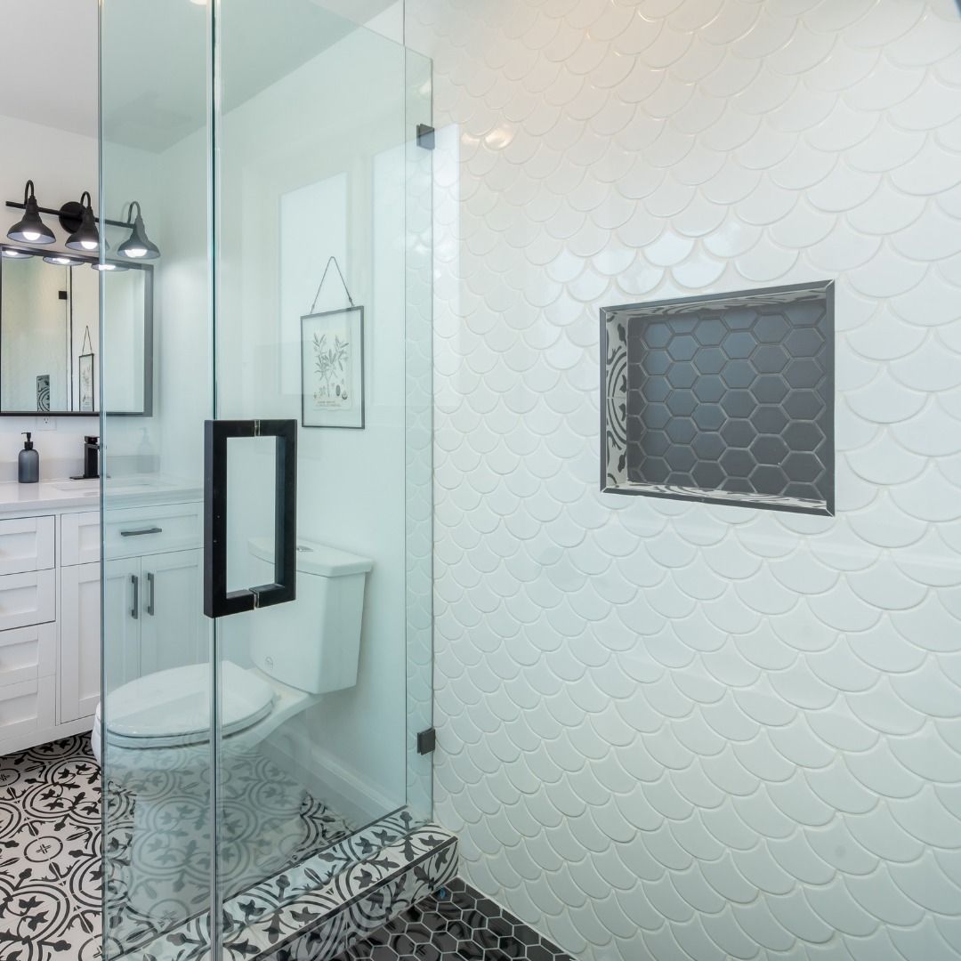A bathroom with a toilet , sink , mirror and shower.