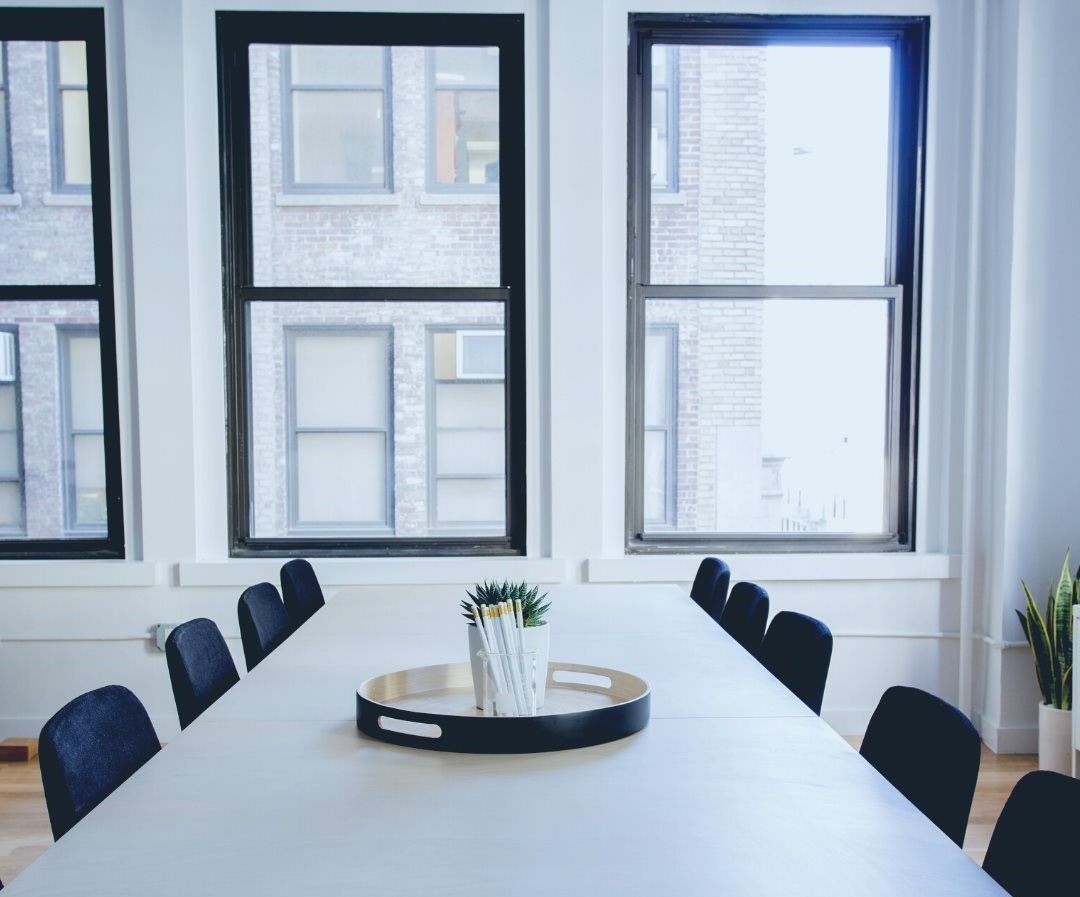 A conference room with a long table and chairs and a tray on the table.
