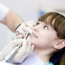 Dentist cleaning a child-s teeth