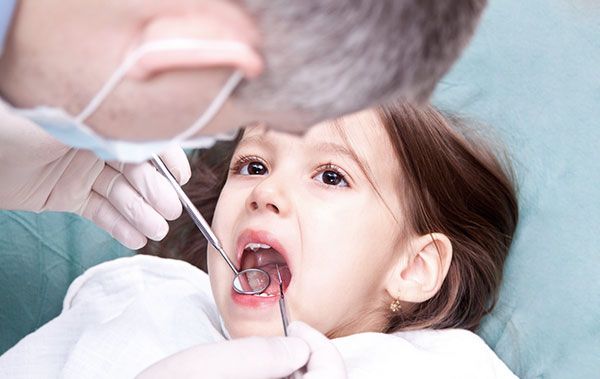 Dentist checking kid-s teeth
