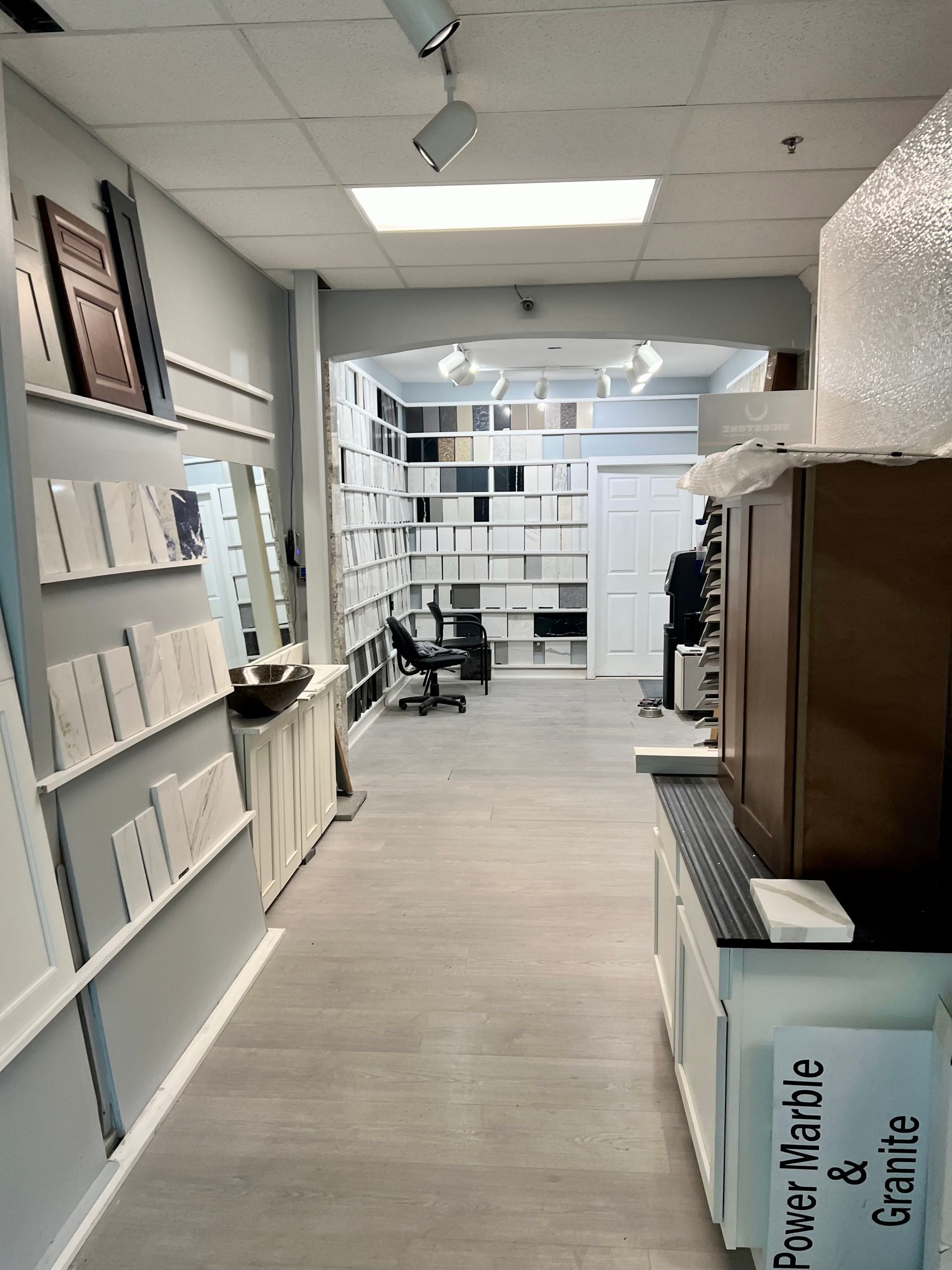 A hallway with a sign that says power marble and granite