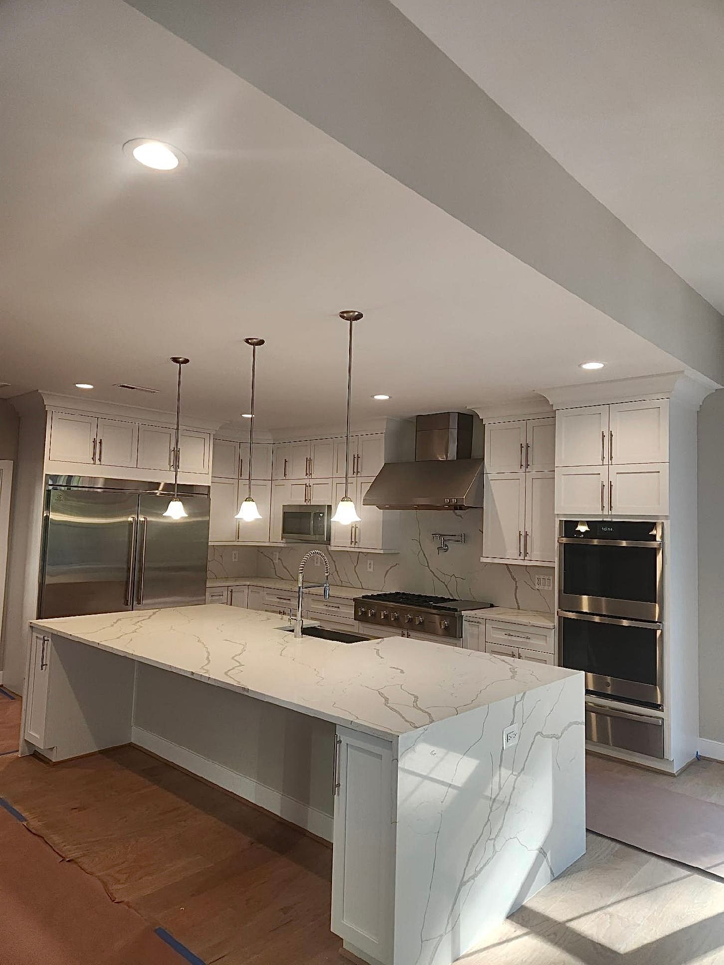A kitchen with a large island and stainless steel appliances