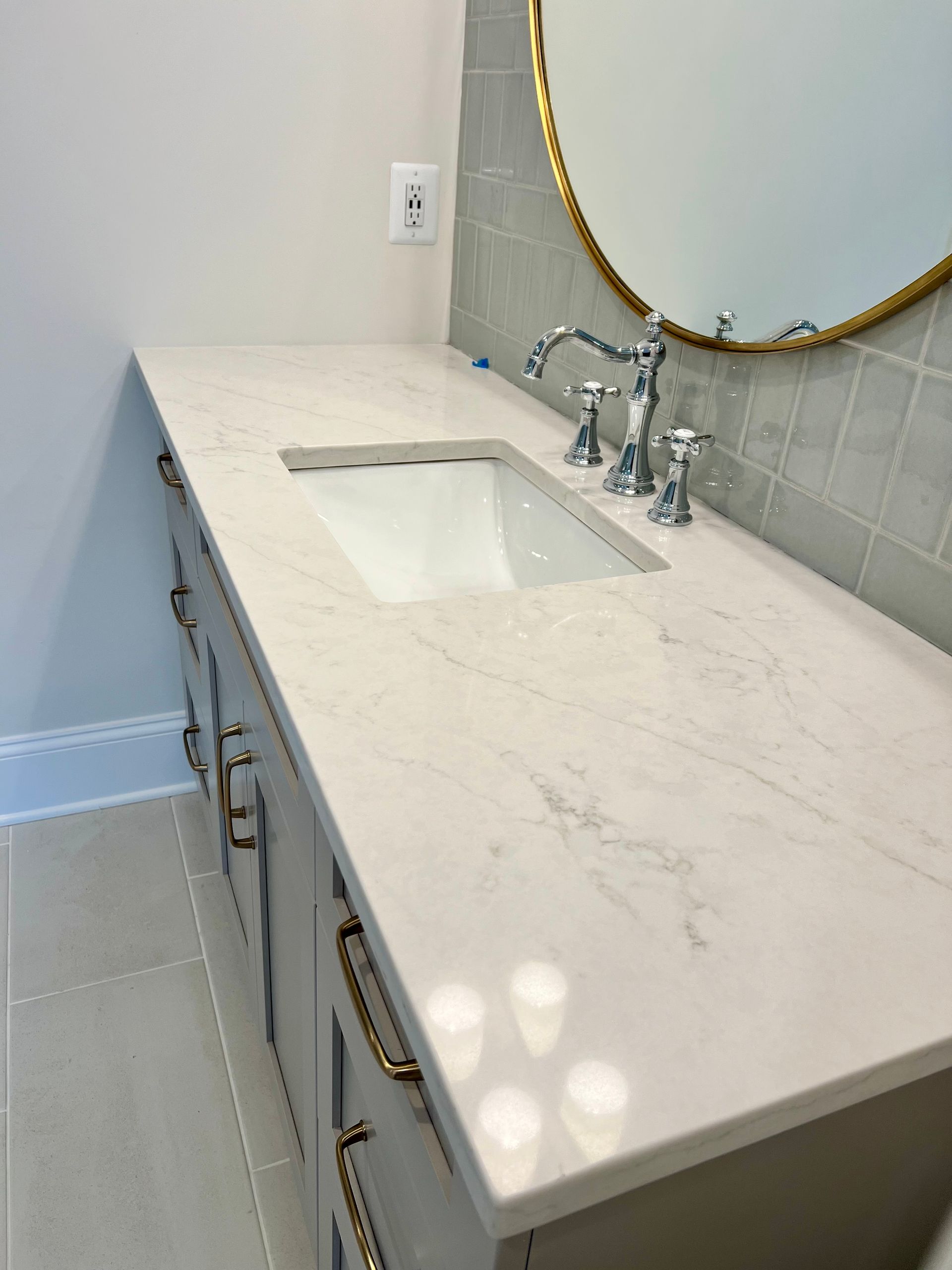 A bathroom with a sink and a mirror on the wall.