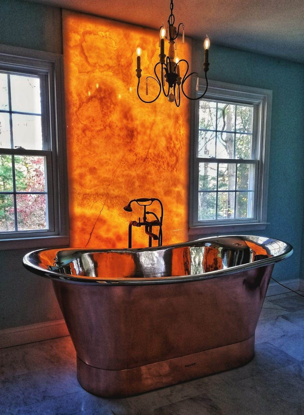 A bathtub in a bathroom with a chandelier hanging from the ceiling