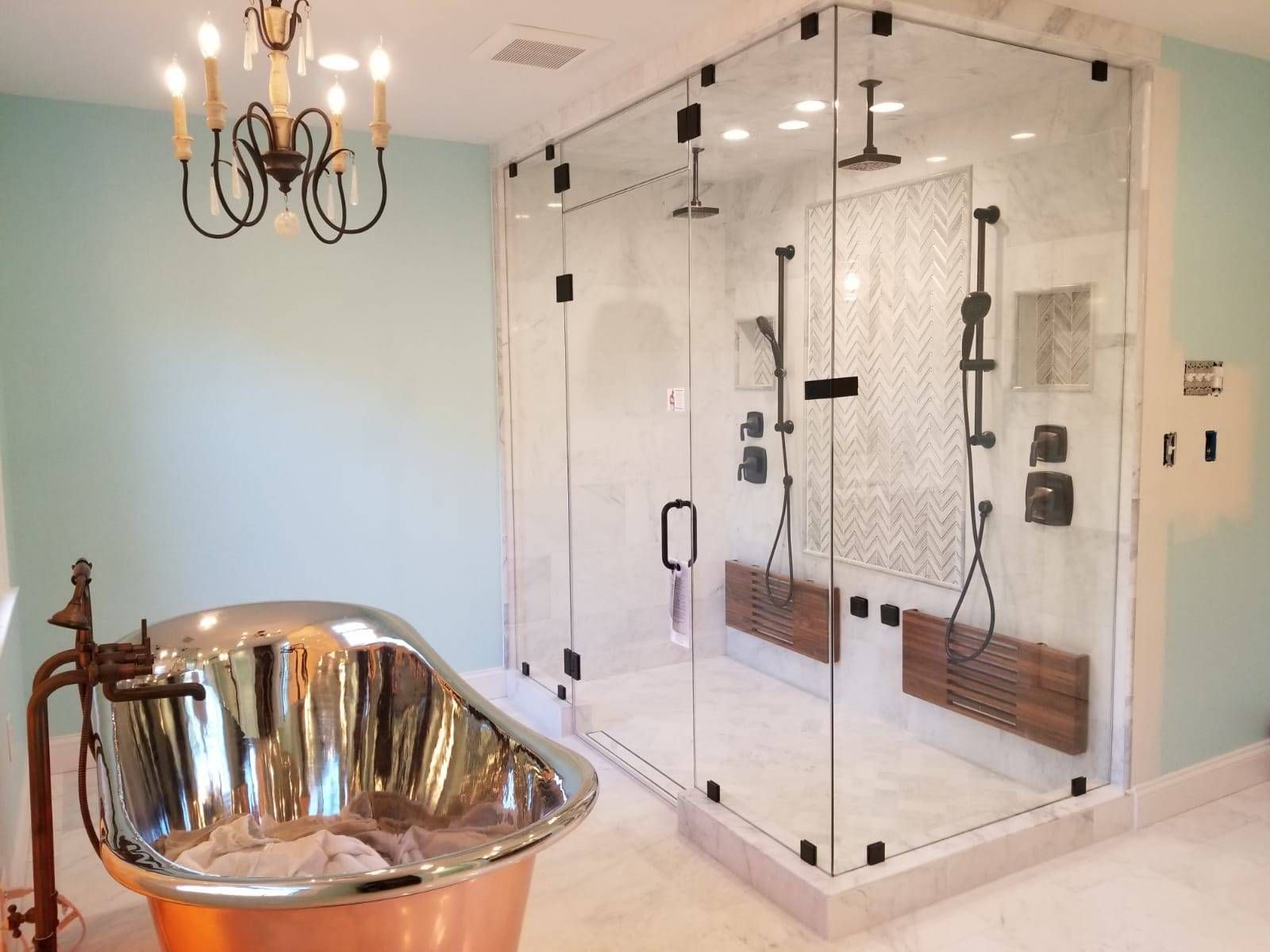 A bathroom with a copper tub and a glass shower