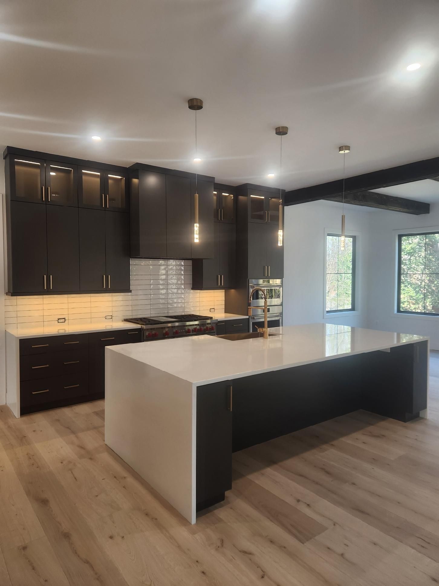 A kitchen with black cabinets and white counter tops