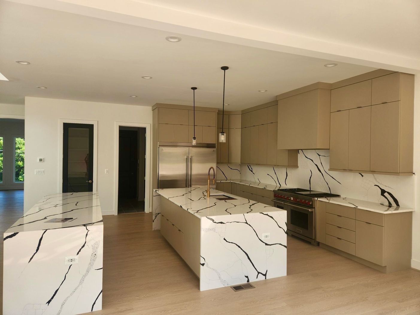 A kitchen with marble counter tops and stainless steel appliances