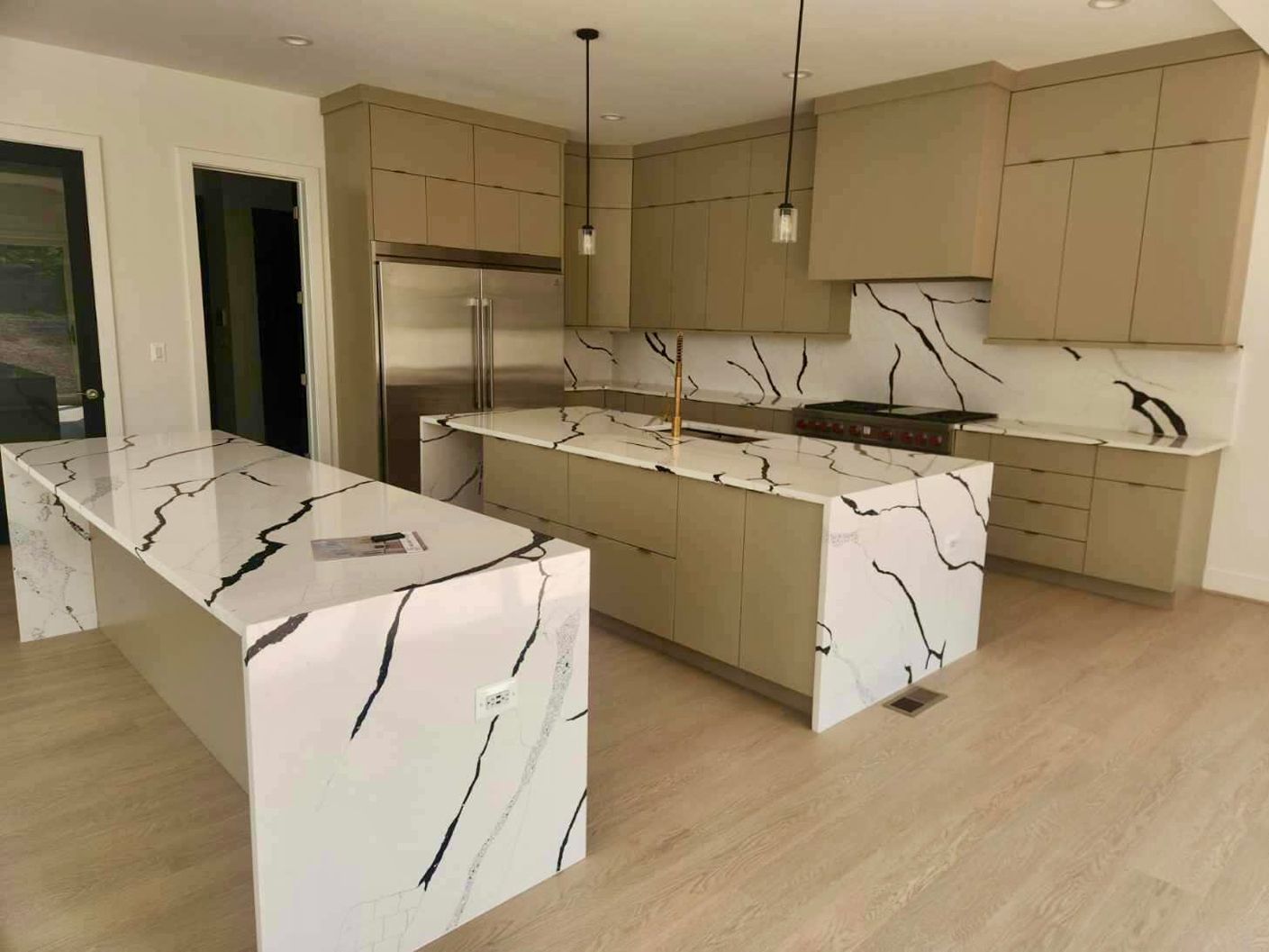 A kitchen with a large island and marble counter tops.