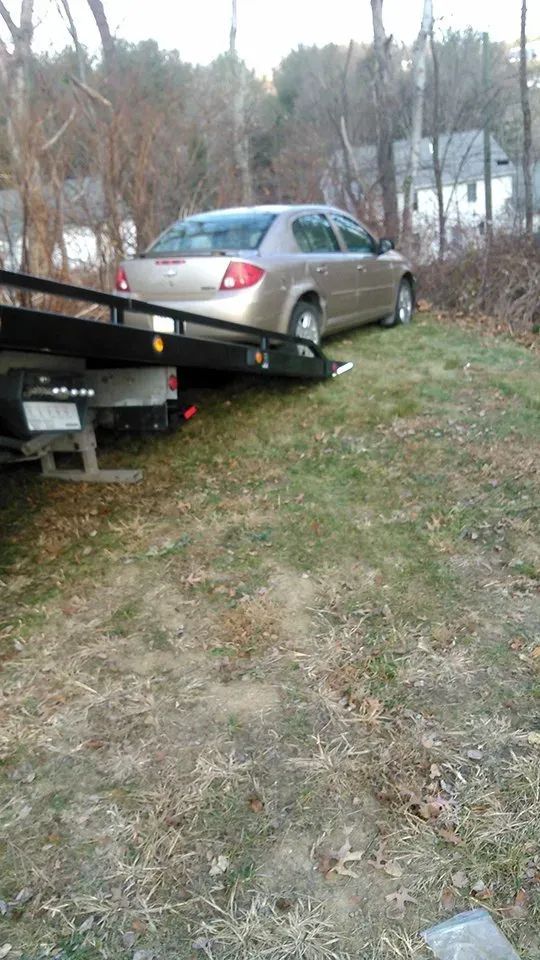 A car is being towed by a tow truck