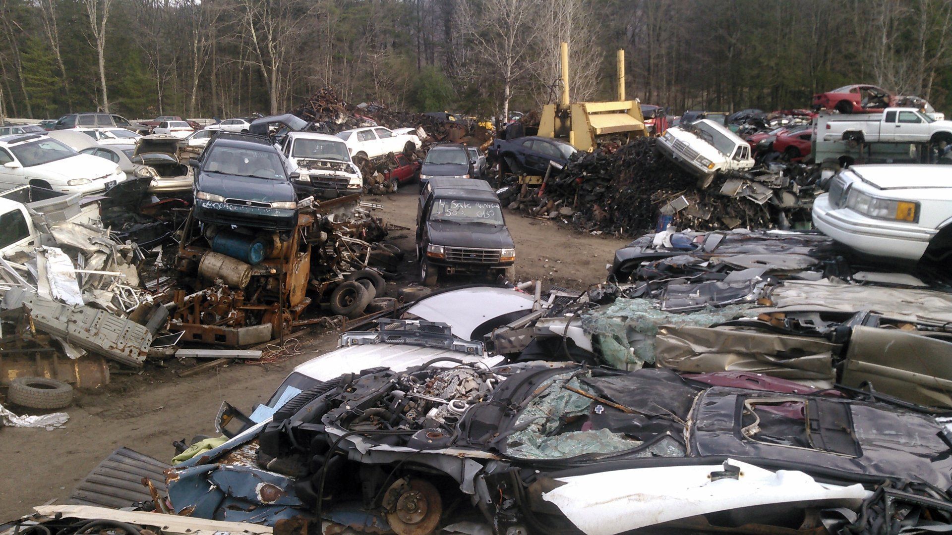 A lot of cars are sitting in a scrap yard