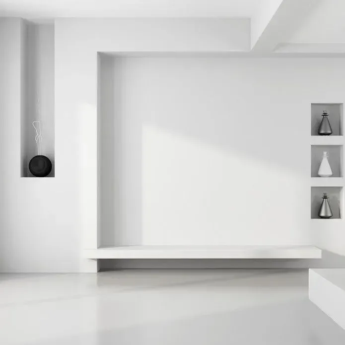Minimalist white interior with a central recessed wall, a floating ledge, and built-in niches displaying abstract decor.
