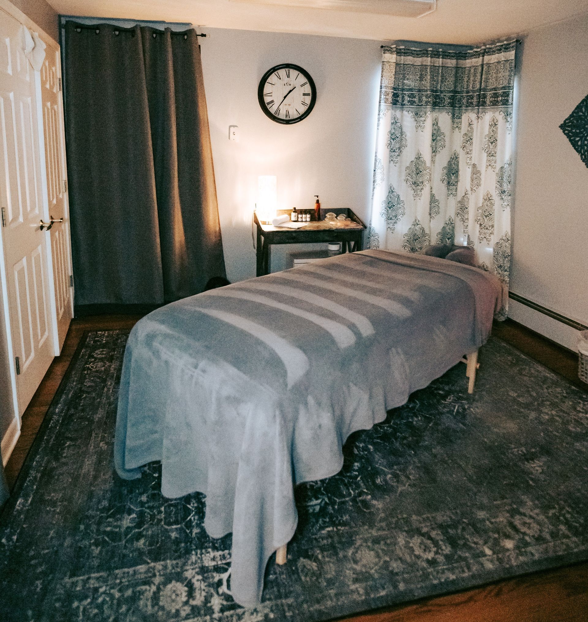 A massage table in a room with a clock on the wall