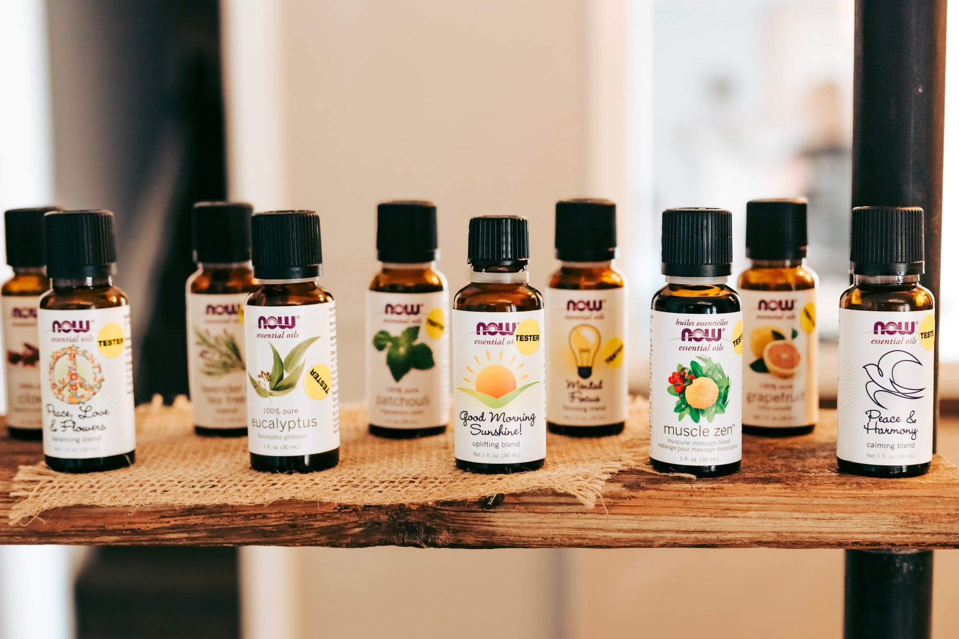 A wooden shelf filled with bottles of essential oils.