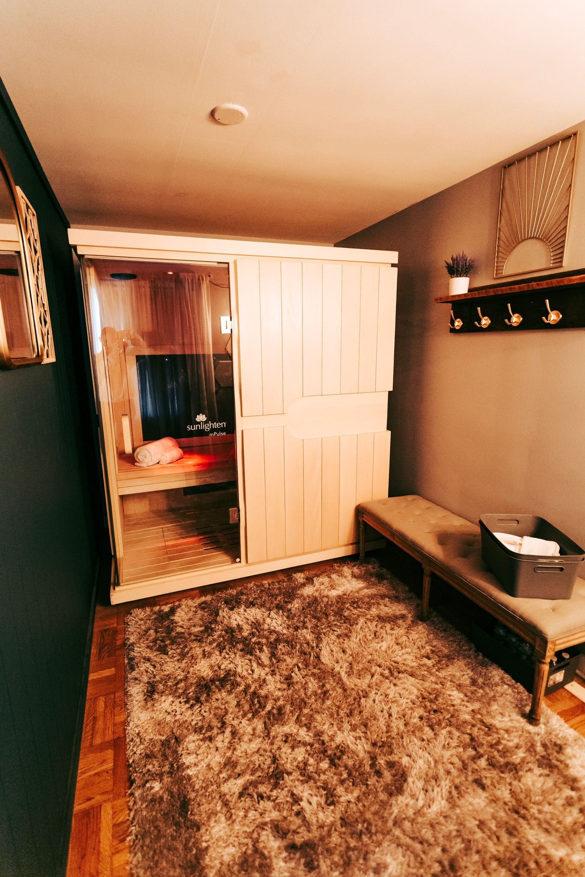 A room with a rug and a bench in it.