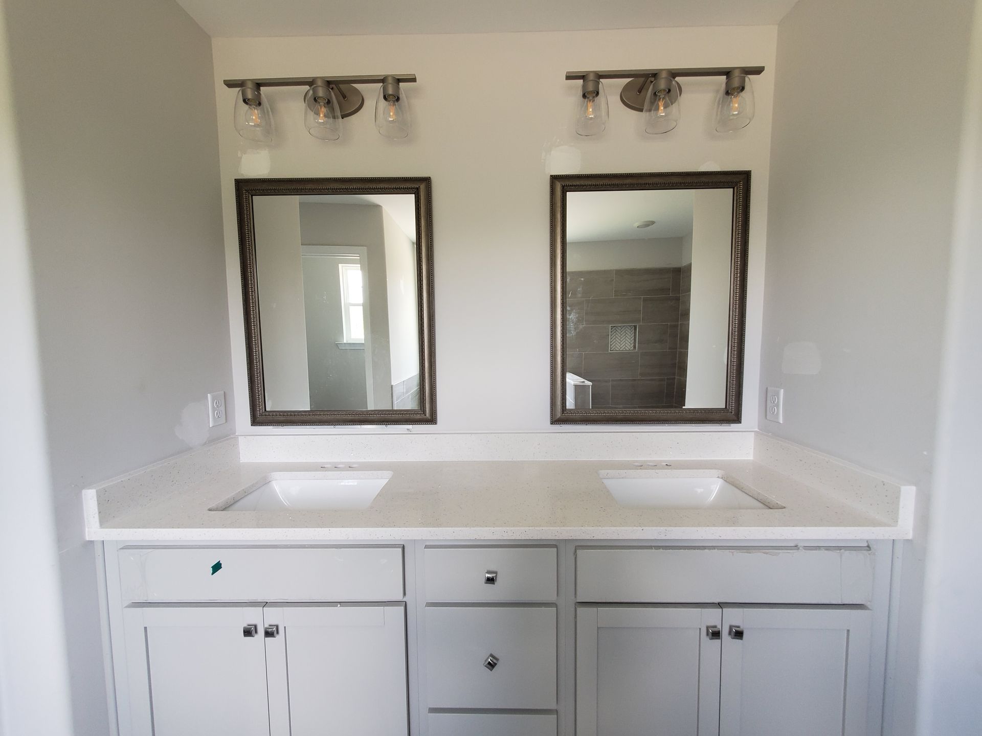 A bathroom with two sinks and two mirrors