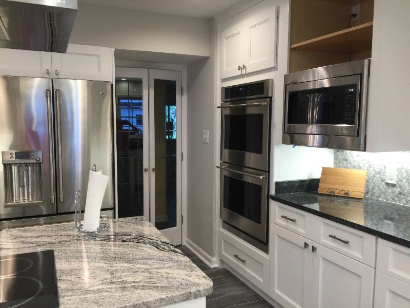 A kitchen with stainless steel appliances and white cabinets
