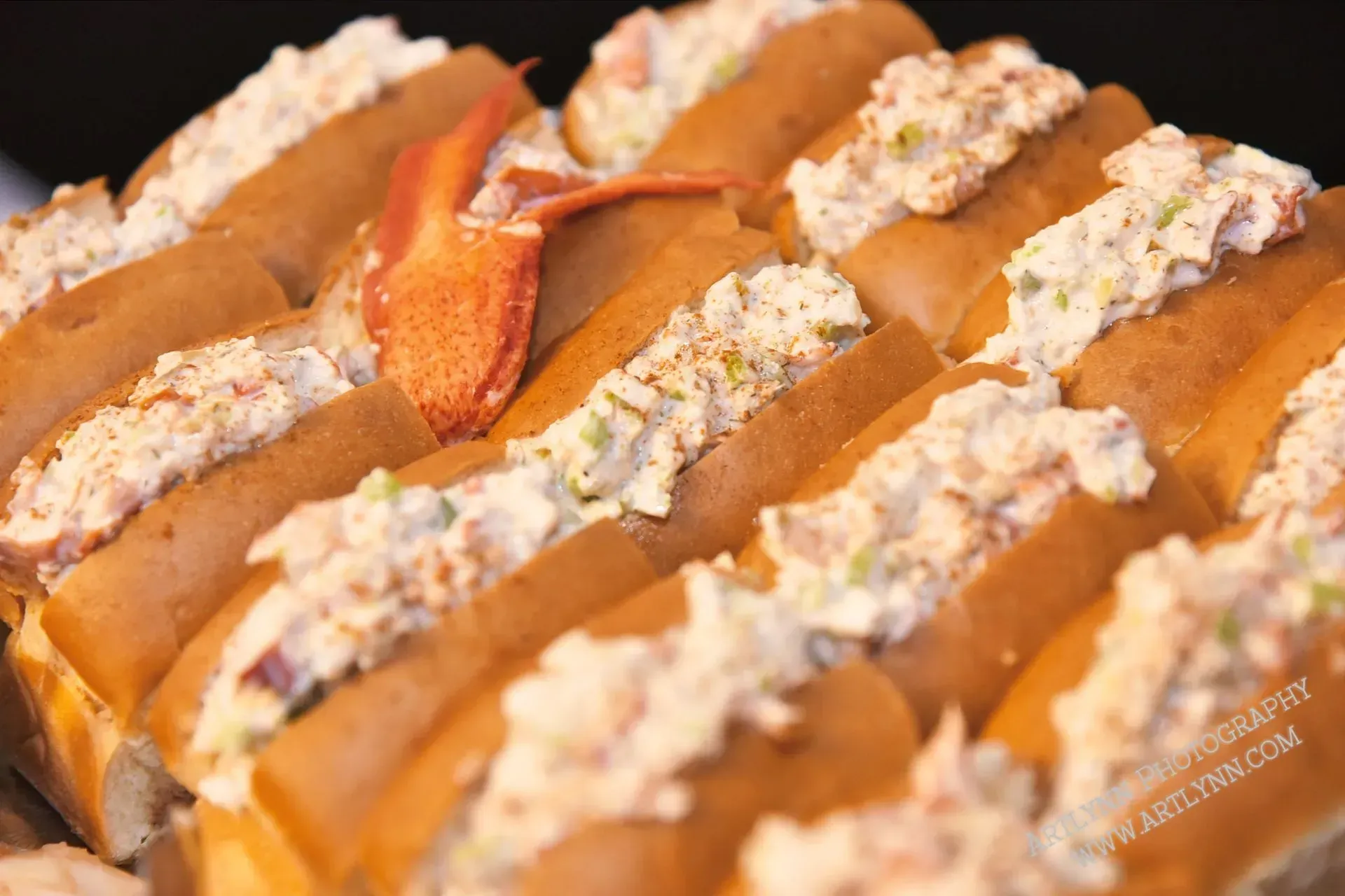 Baguette slices topped with creamy spread and orange sauce on a tray