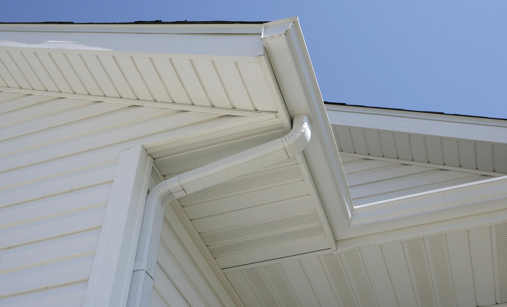 a white house with a gutter on the side of it