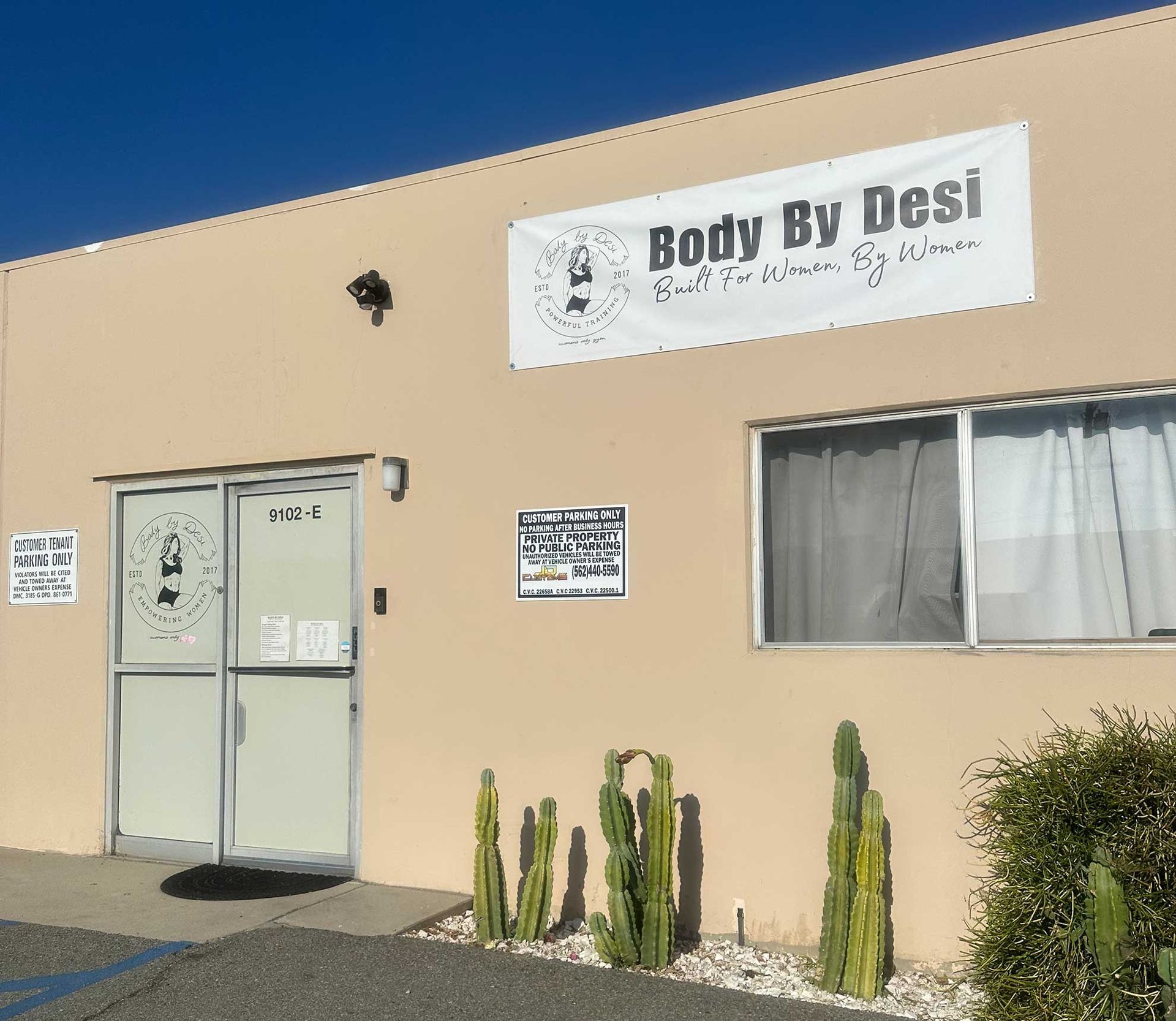 Body By Desi fitness studio exterior with sign, door, window, cacti.
