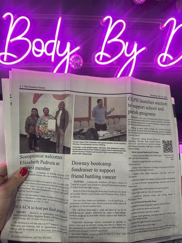 Person holding a newspaper with articles, lit by a pink neon sign that says Body By B.