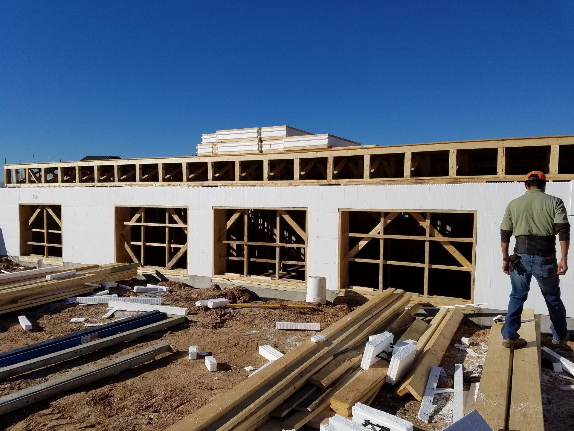 A man is standing in front of a building under construction