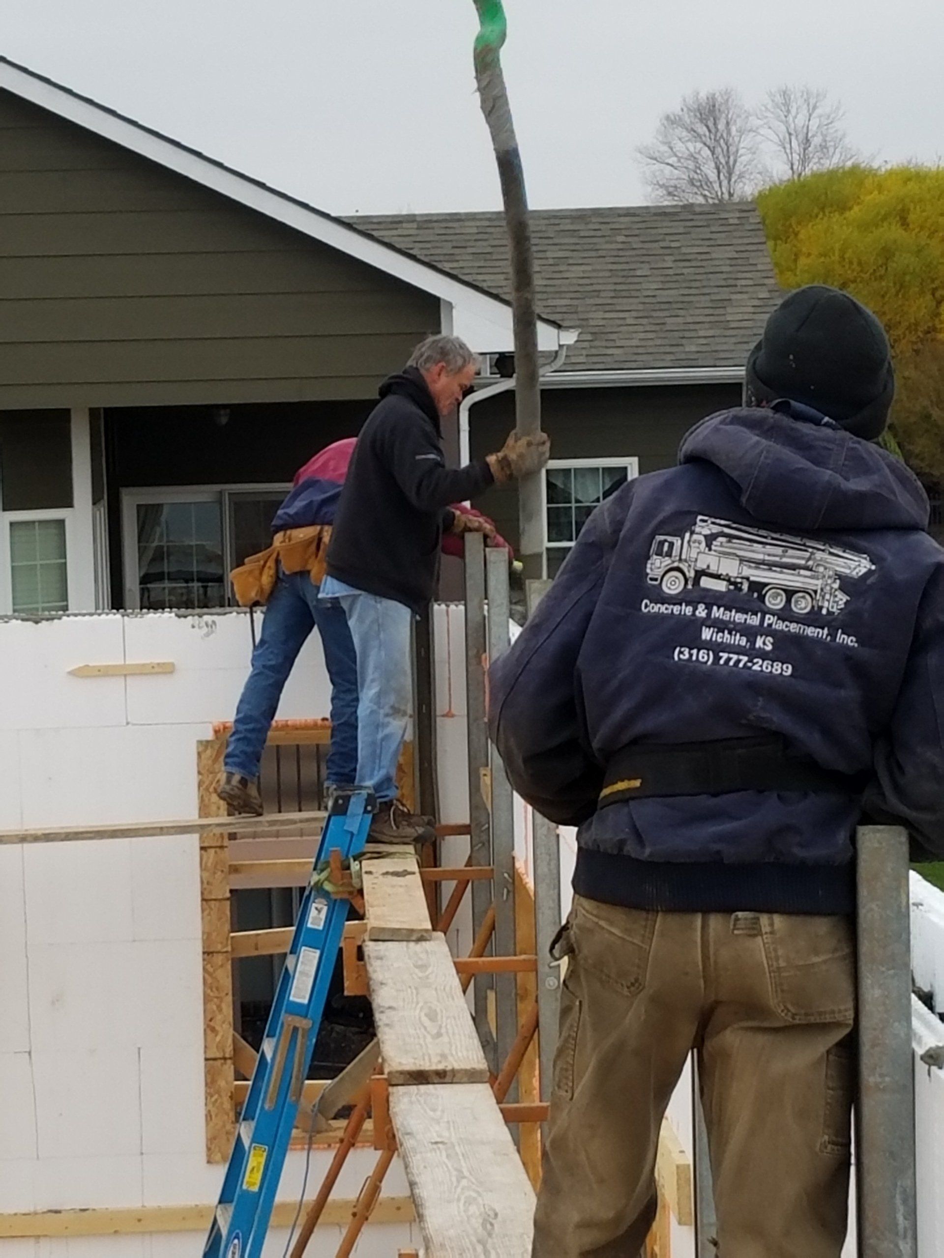 A man wearing a blue jacket that says ' construction ' on it