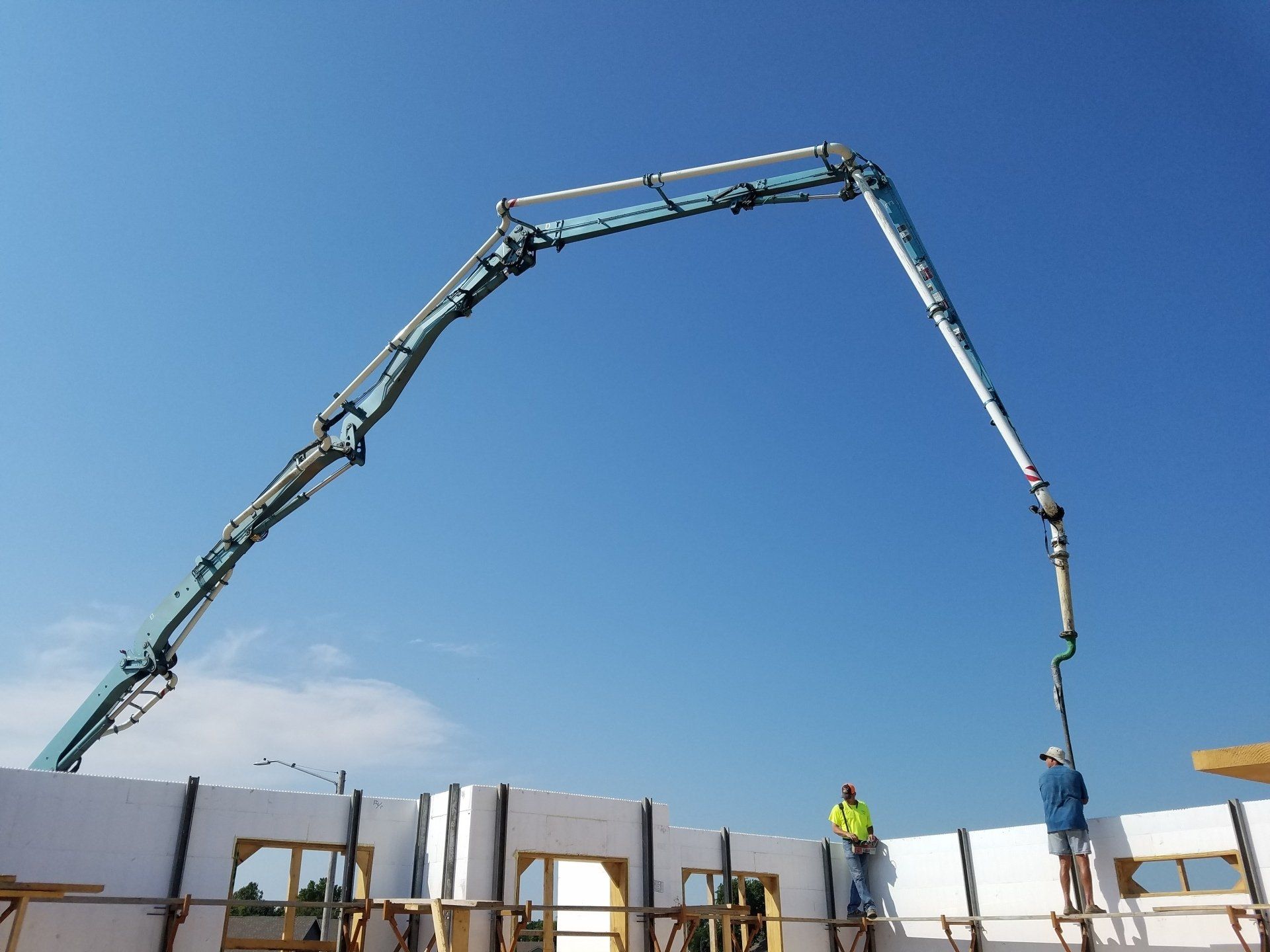 A concrete pump is being used to pour concrete into a building