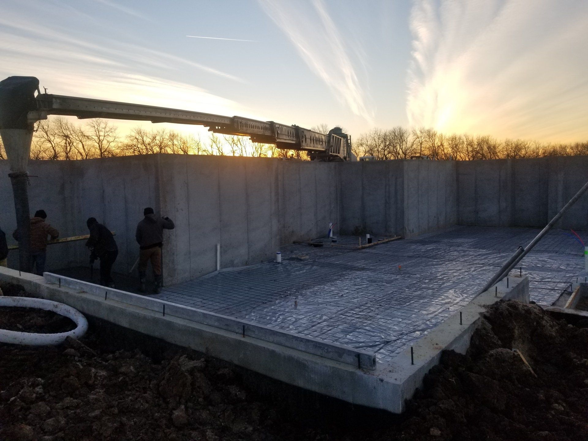 A concrete pump is being used to pour concrete into a foundation.