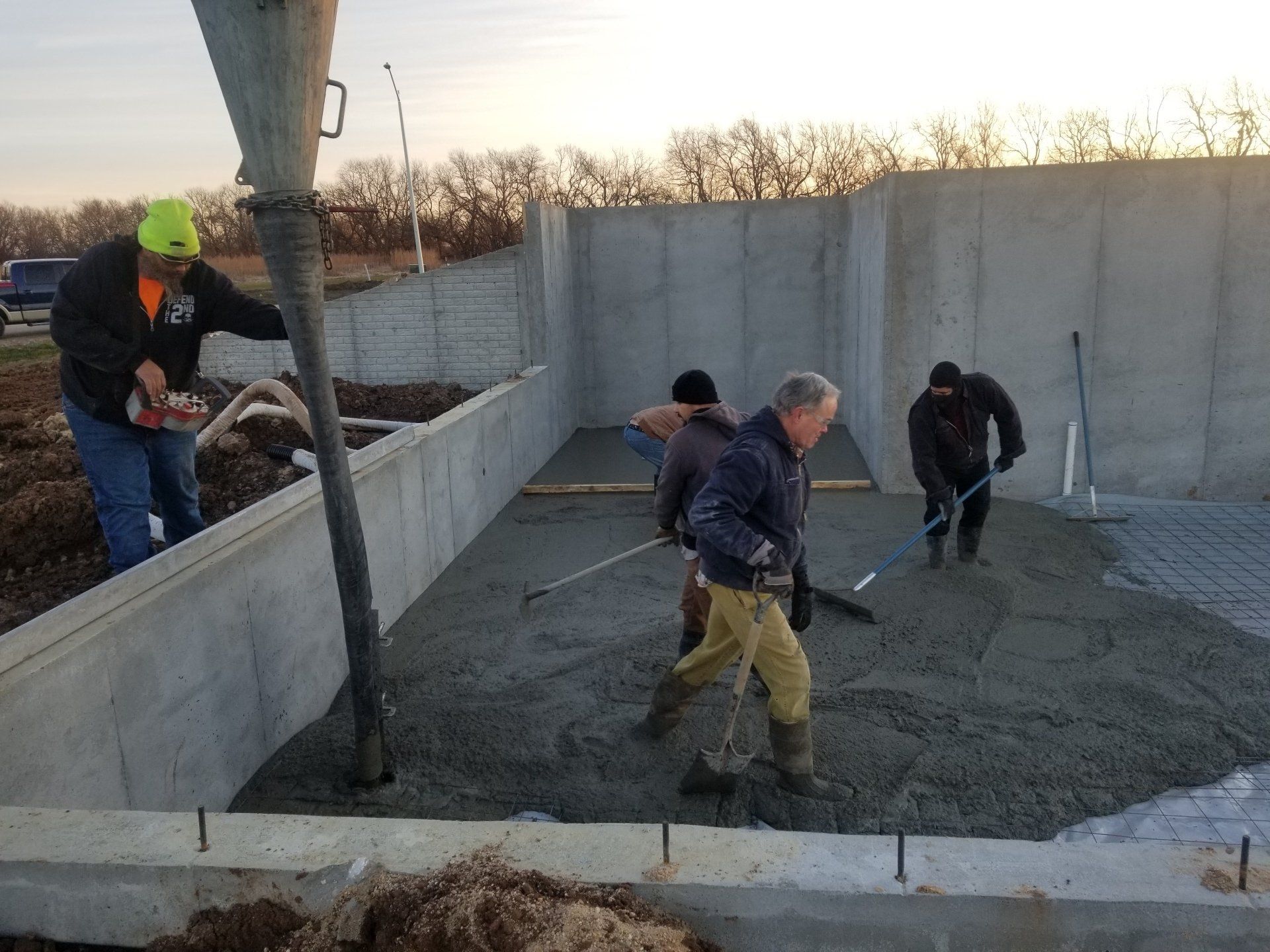 A group of men are working on a concrete floor