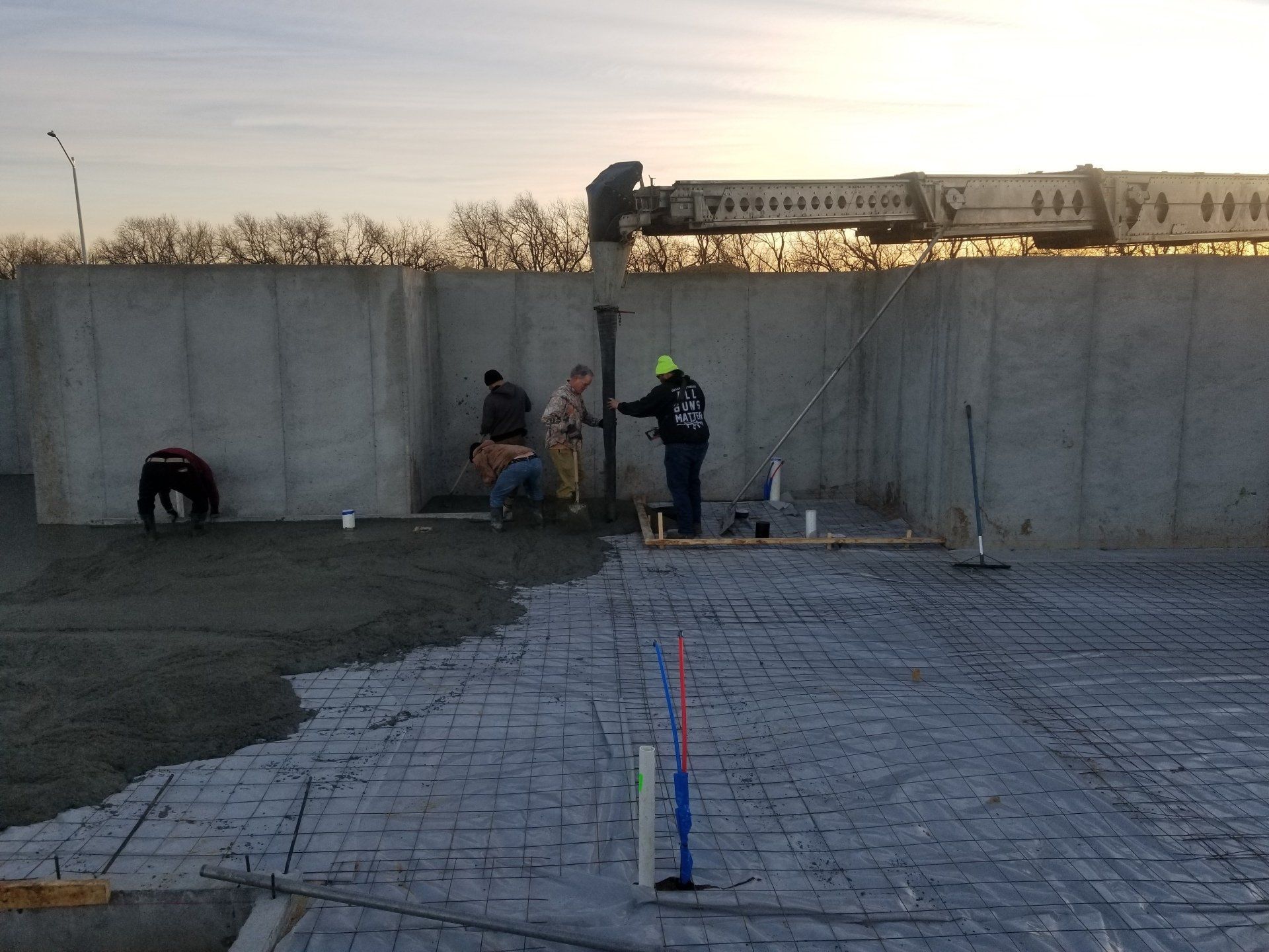 A group of construction workers are working on a concrete floor.