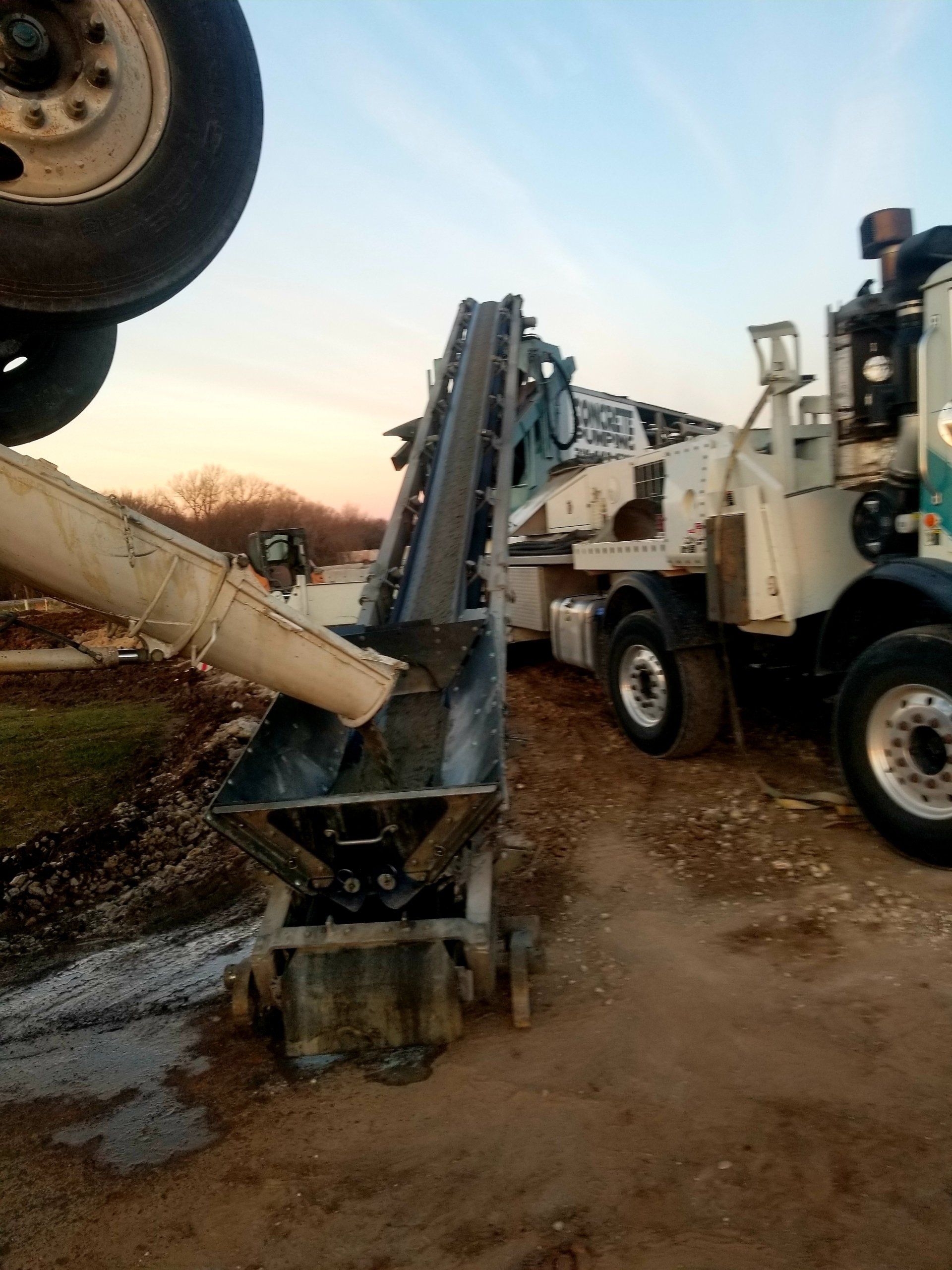 A concrete truck is pouring concrete into a bucket