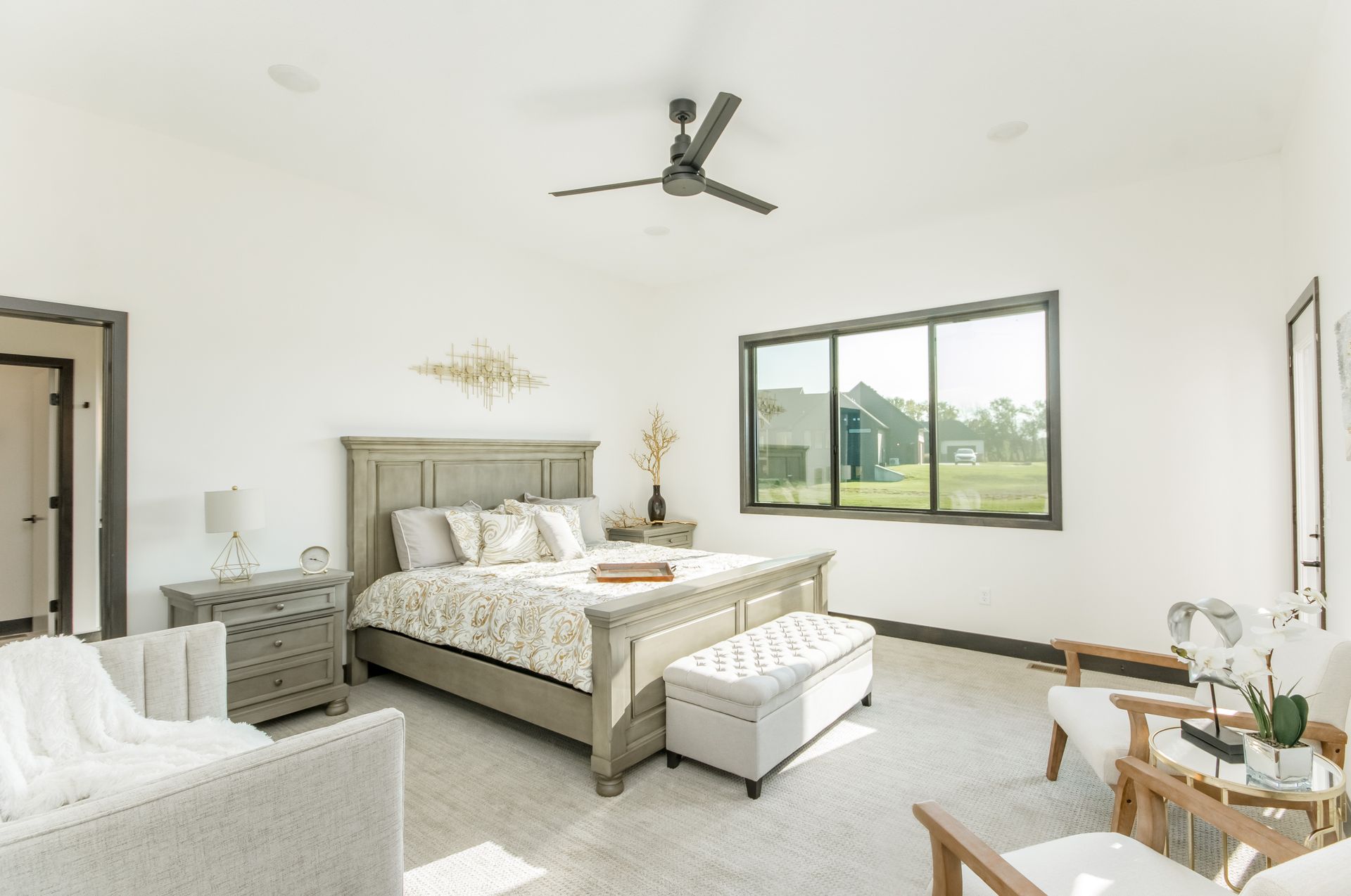 A bedroom with a large bed and a ceiling fan.