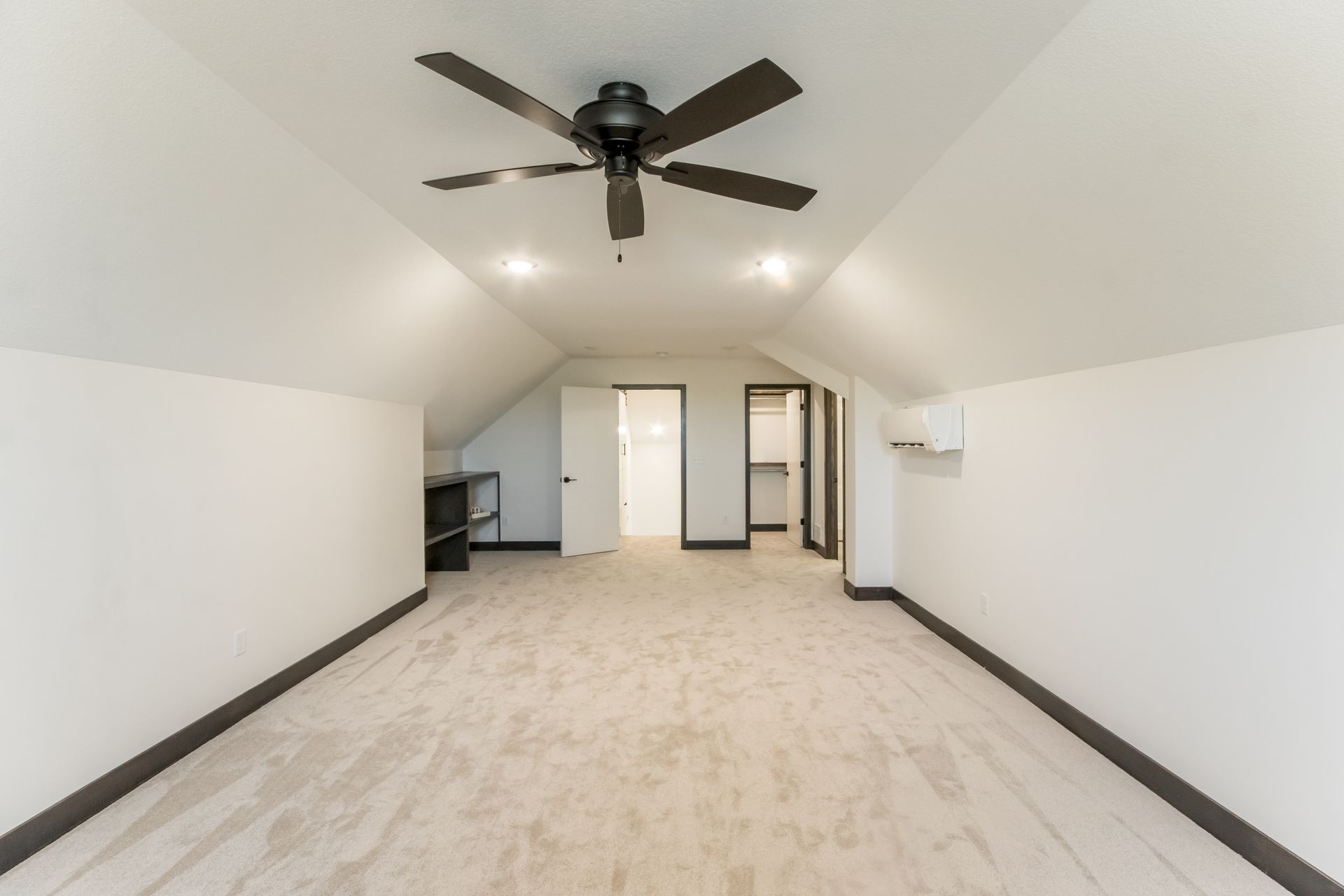 An empty room with a ceiling fan in the corner