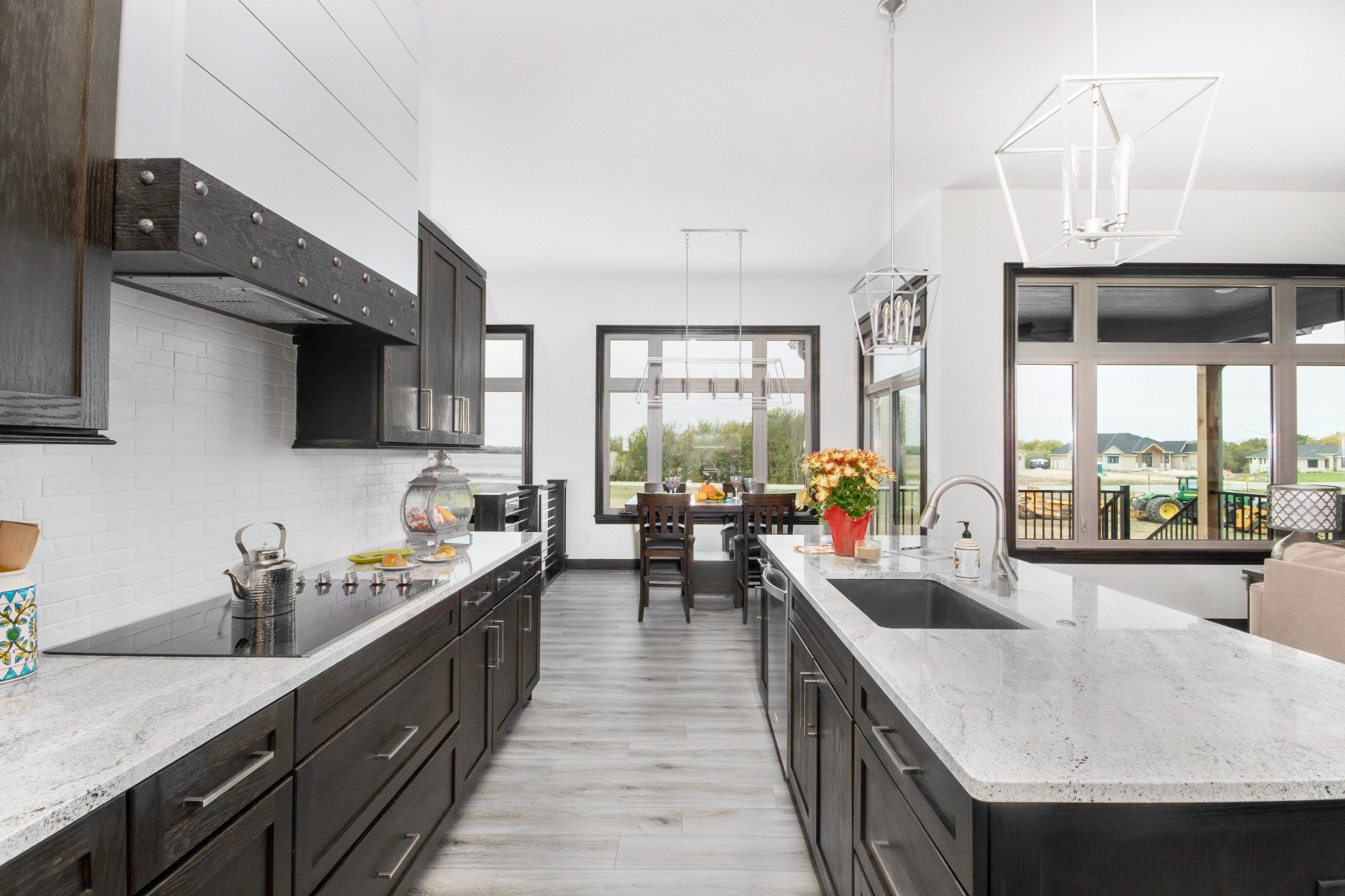 A kitchen with a large sink , stove , cabinets and counter tops.