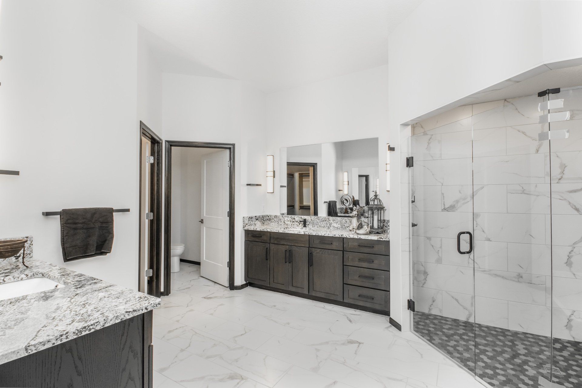 A bathroom with two sinks and a walk in shower.