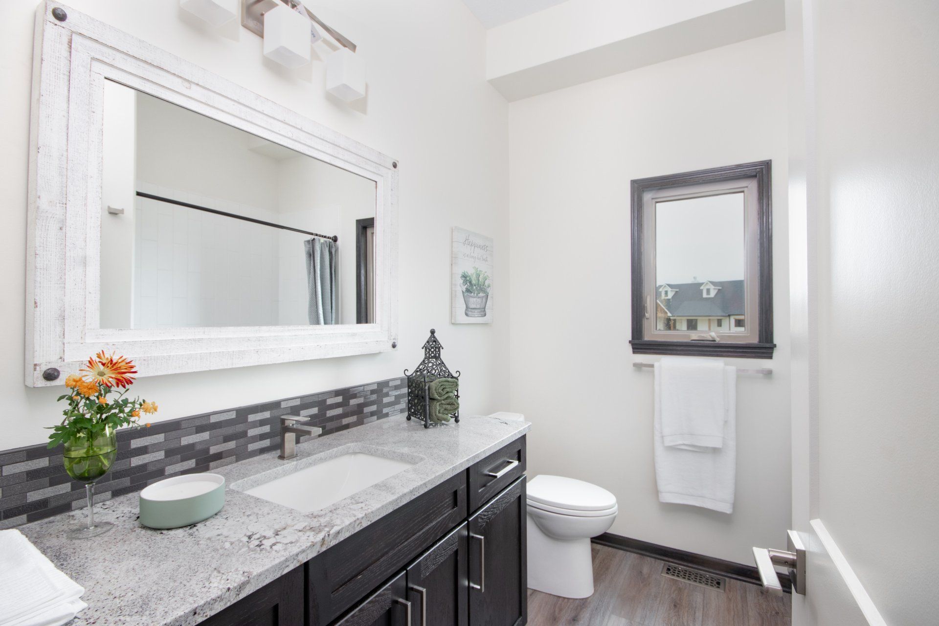 A bathroom with a sink , toilet and mirror.