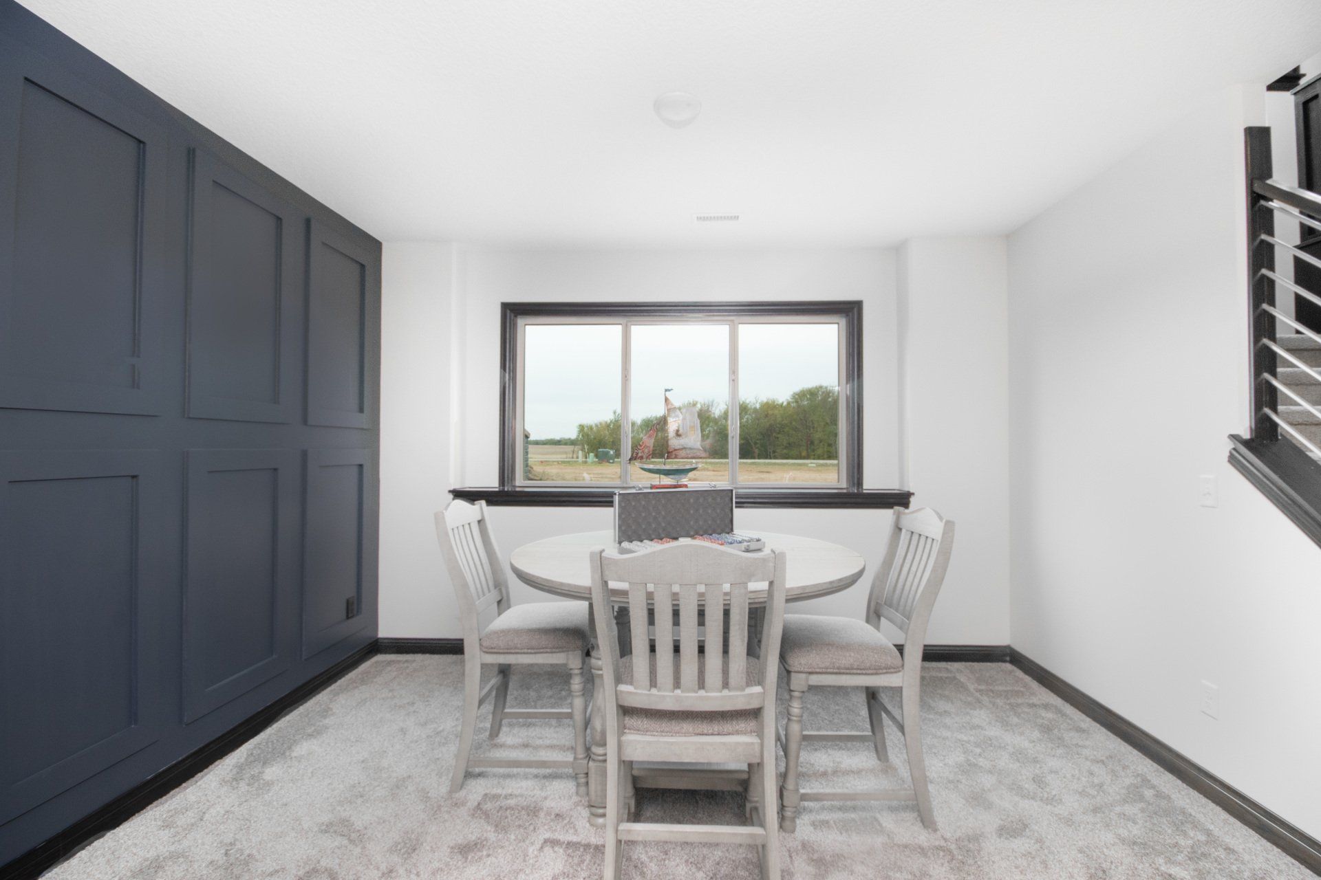 A dining room with a table and chairs and a large window.