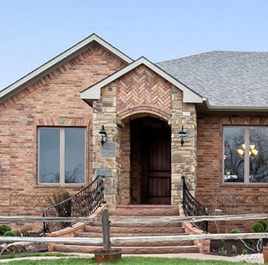 A brick house with stairs leading up to the front door