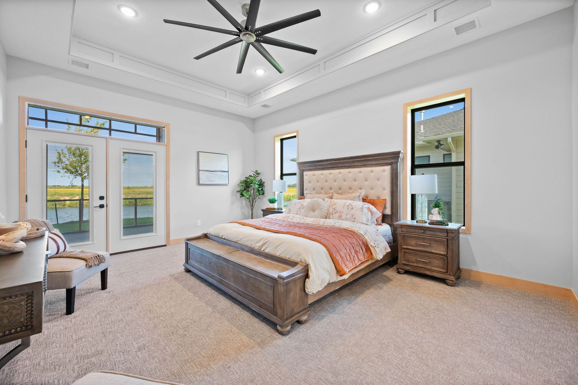 A bedroom with a large bed and a ceiling fan.