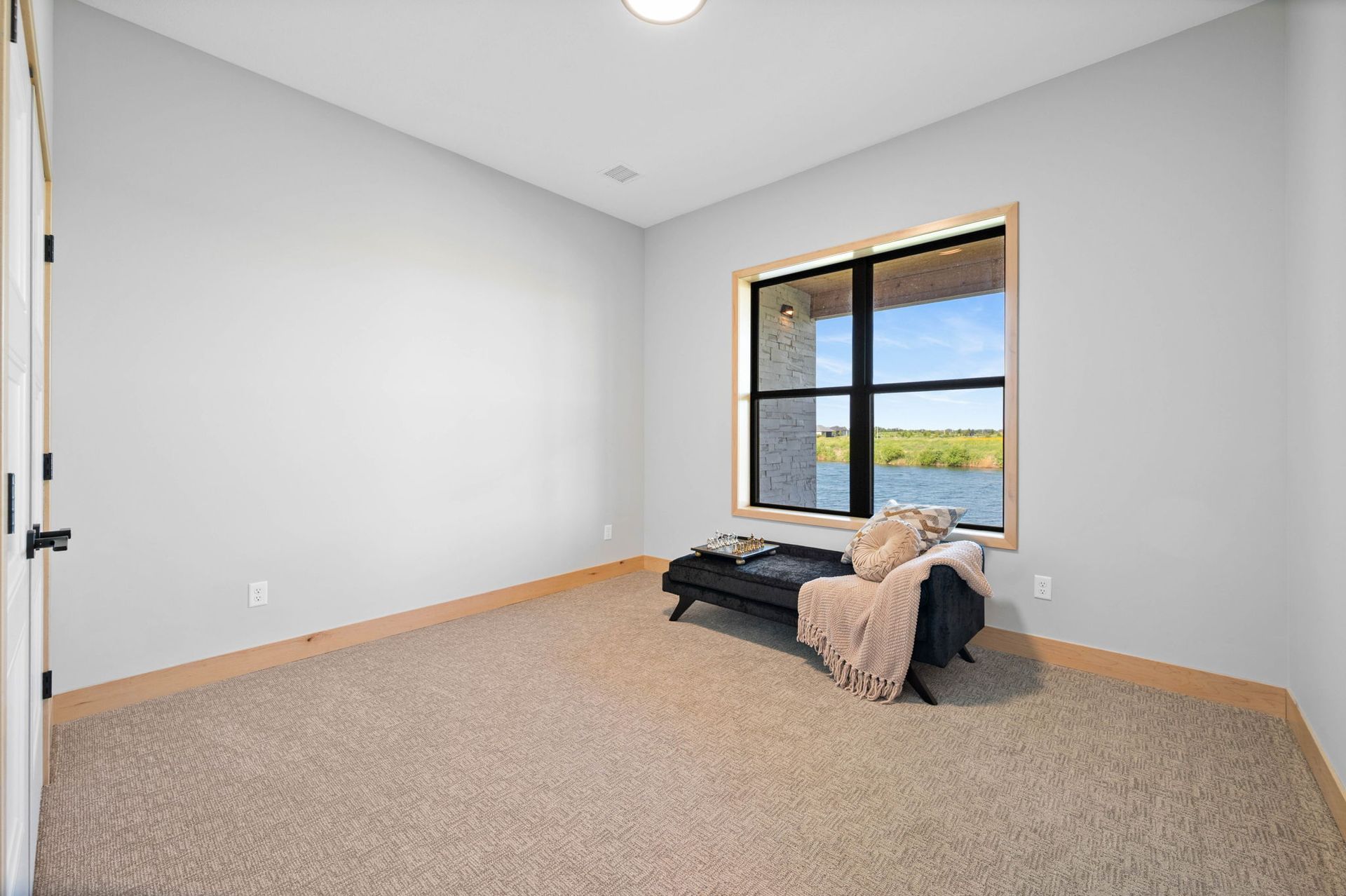 An empty room with a window and a bench in it.