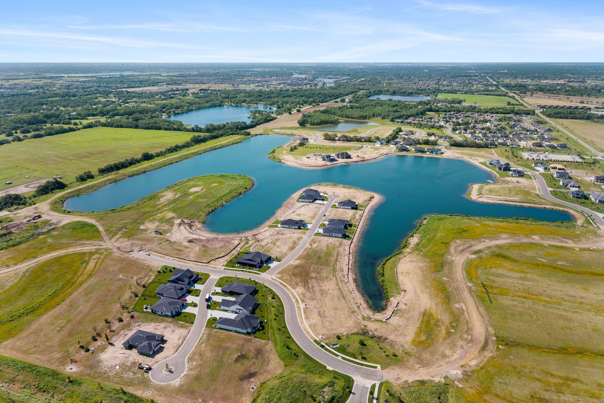 An aerial view of a residential area with a lake in the middle.