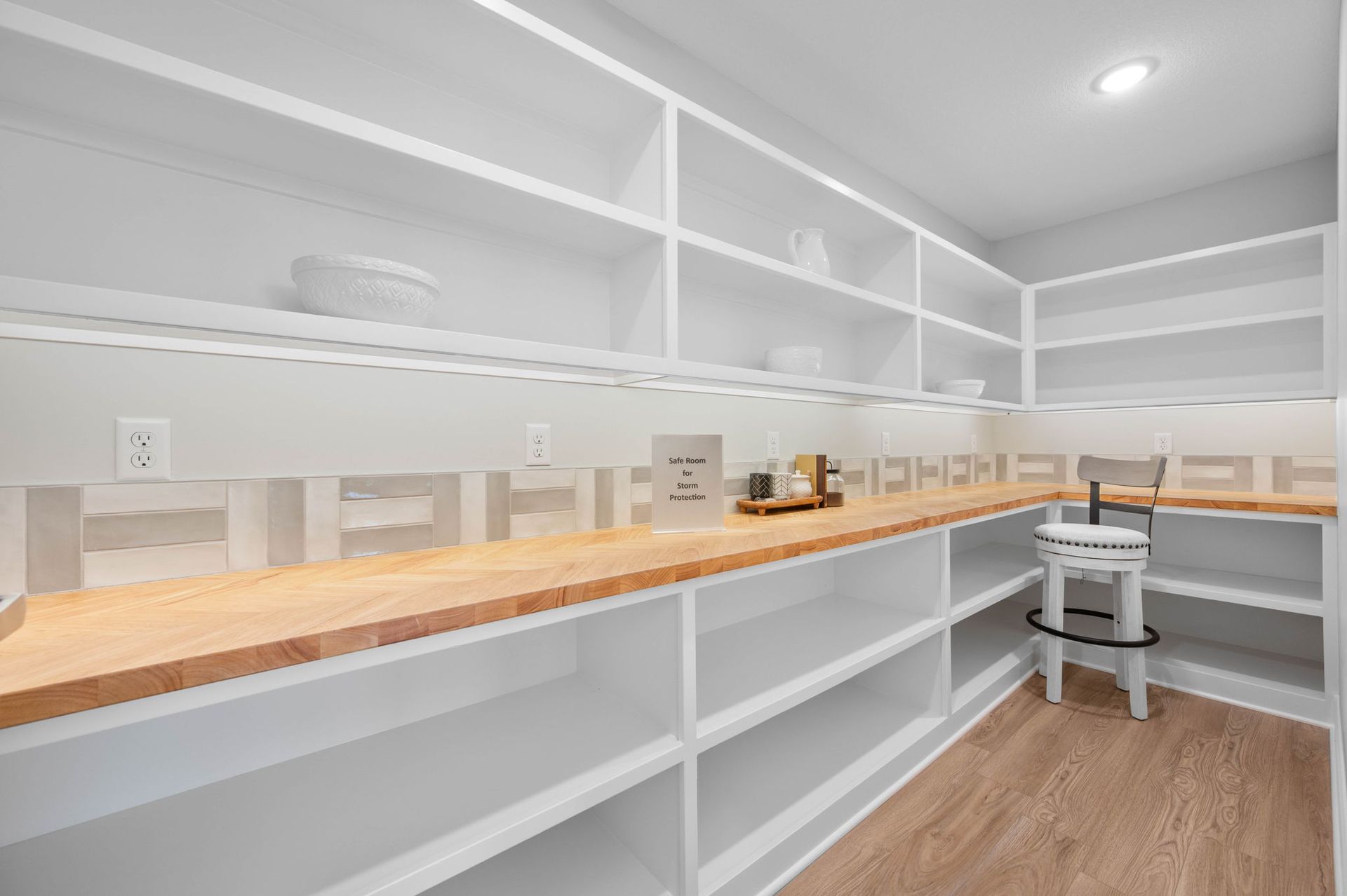 A pantry with lots of shelves and a wooden counter top.