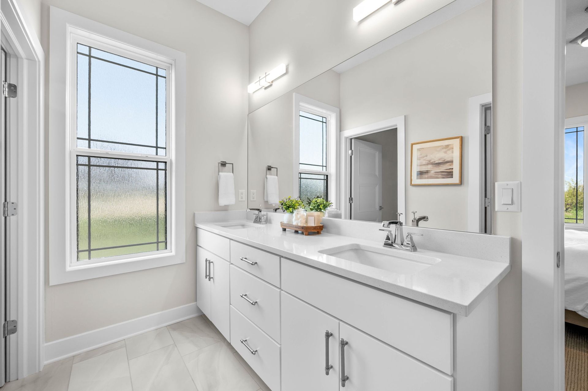 A bathroom with two sinks and a large mirror.