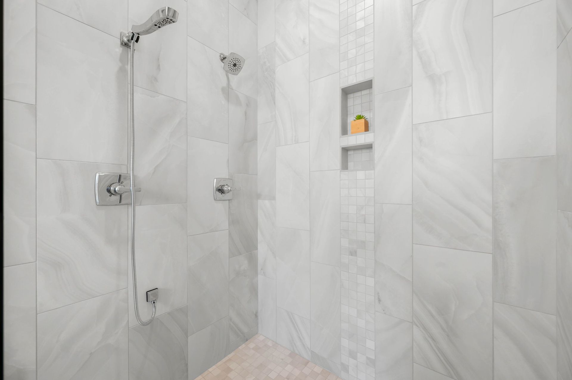 A bathroom with white tiles and a walk in shower.