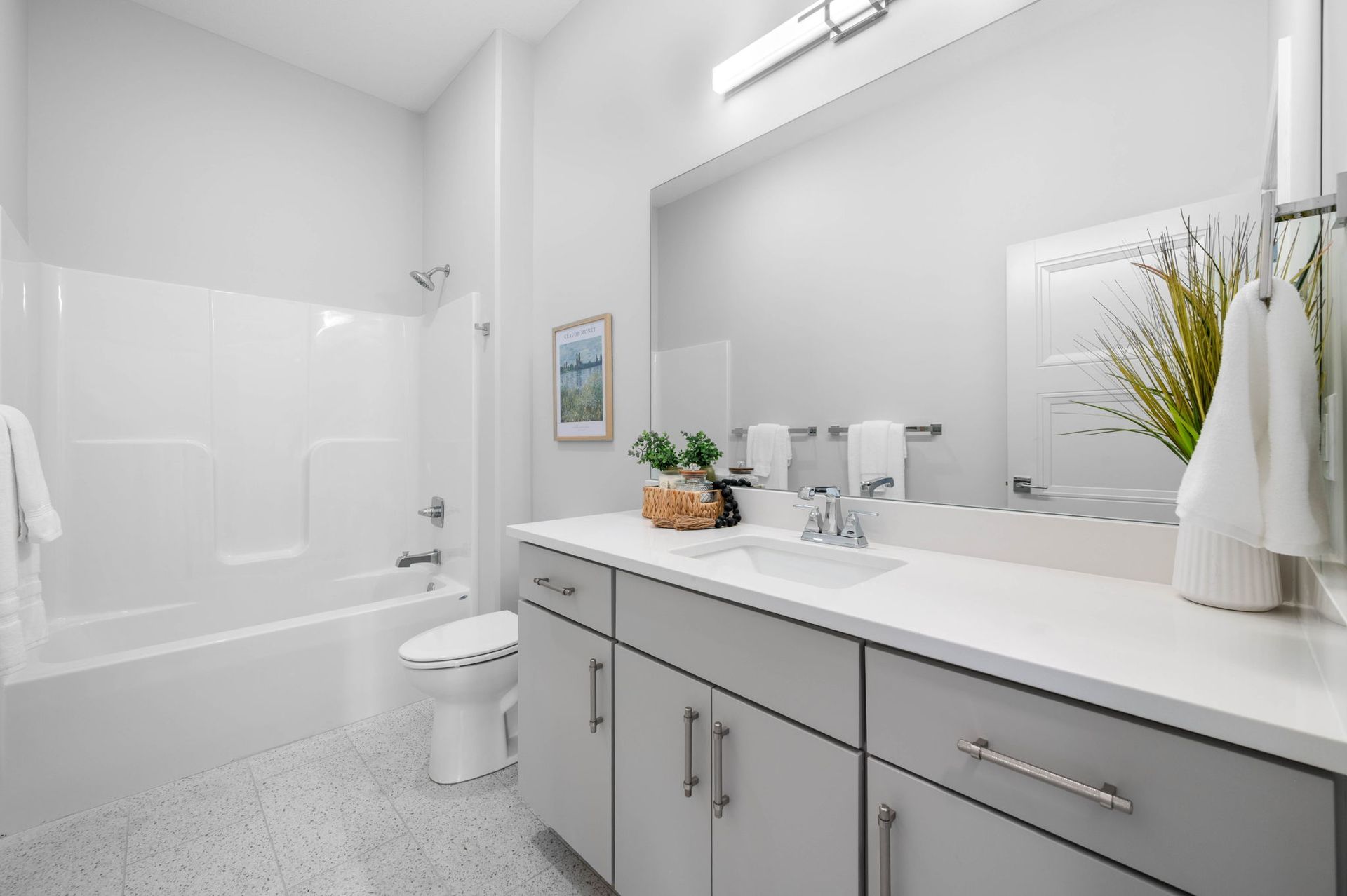 A bathroom with a sink, toilet, bathtub, and mirror.
