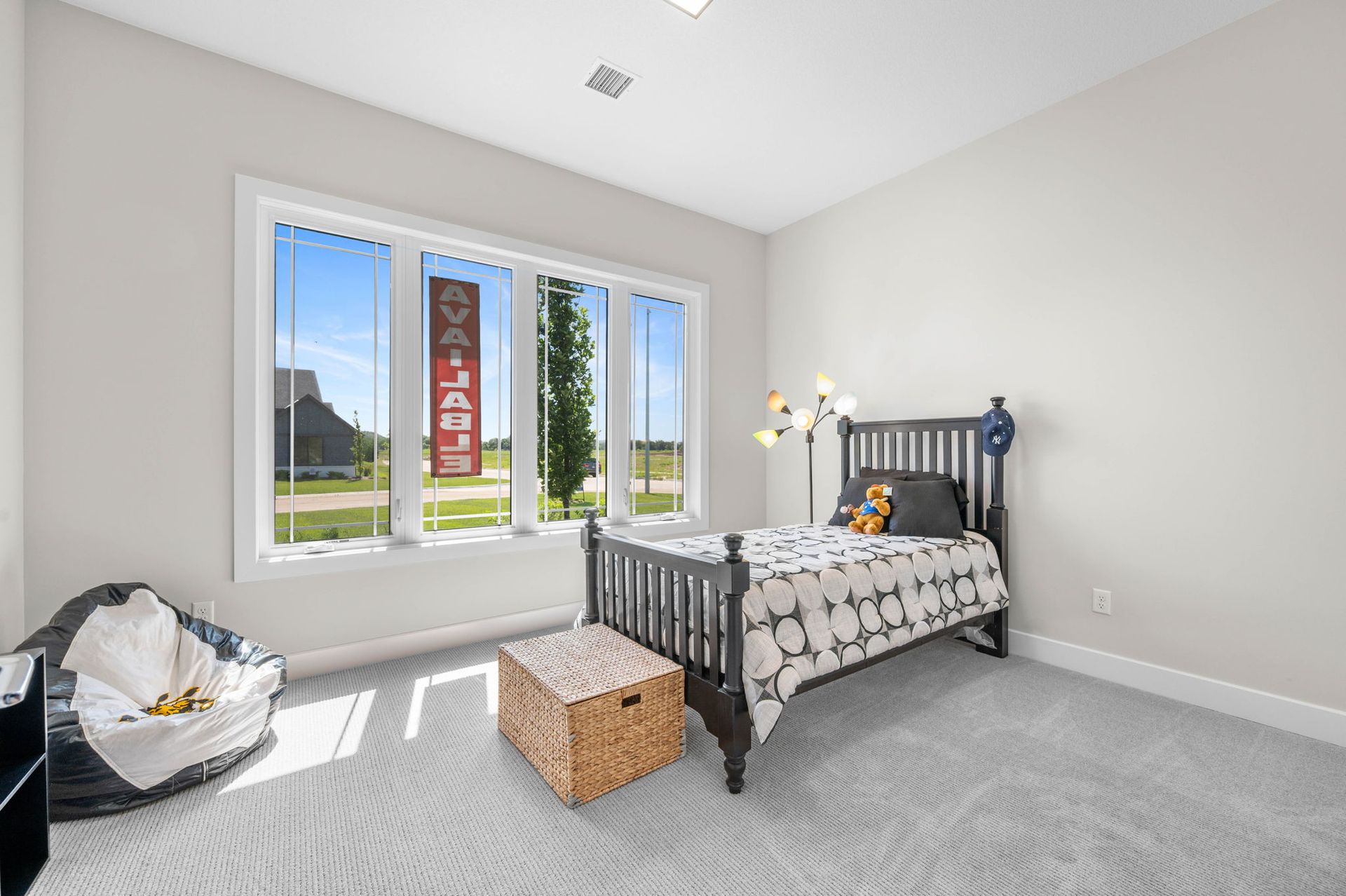 A bedroom with a bed, window, and a bean bag chair.