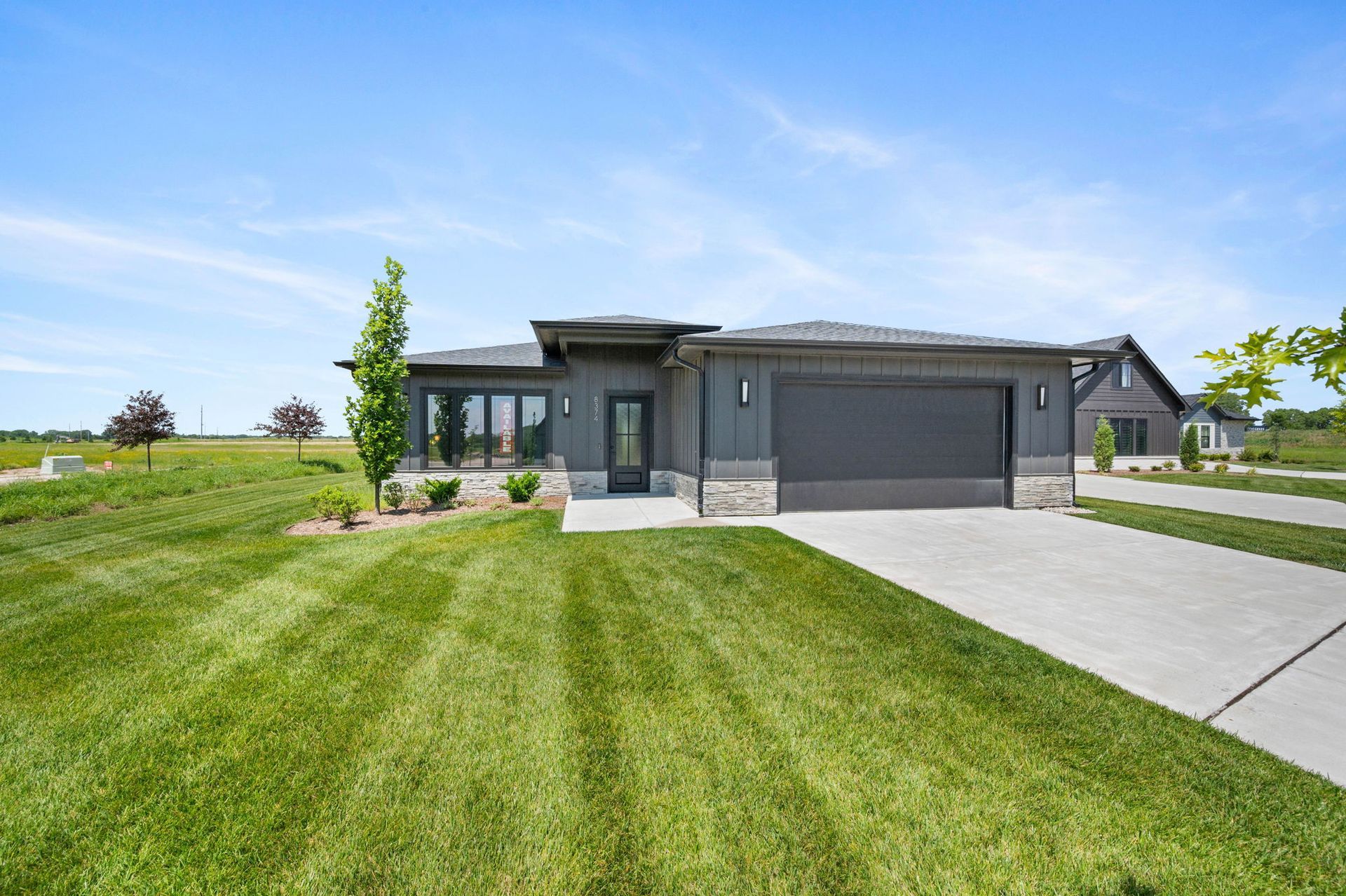 The front of a house with a lush green lawn and a garage.